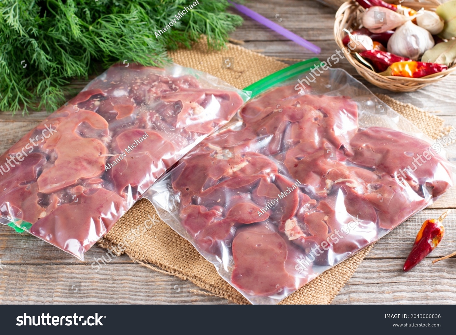 Frozen offal, liver, heart, stomachs in a plastic bag on a wooden table. Frozen products. Frozen food #2043000836
