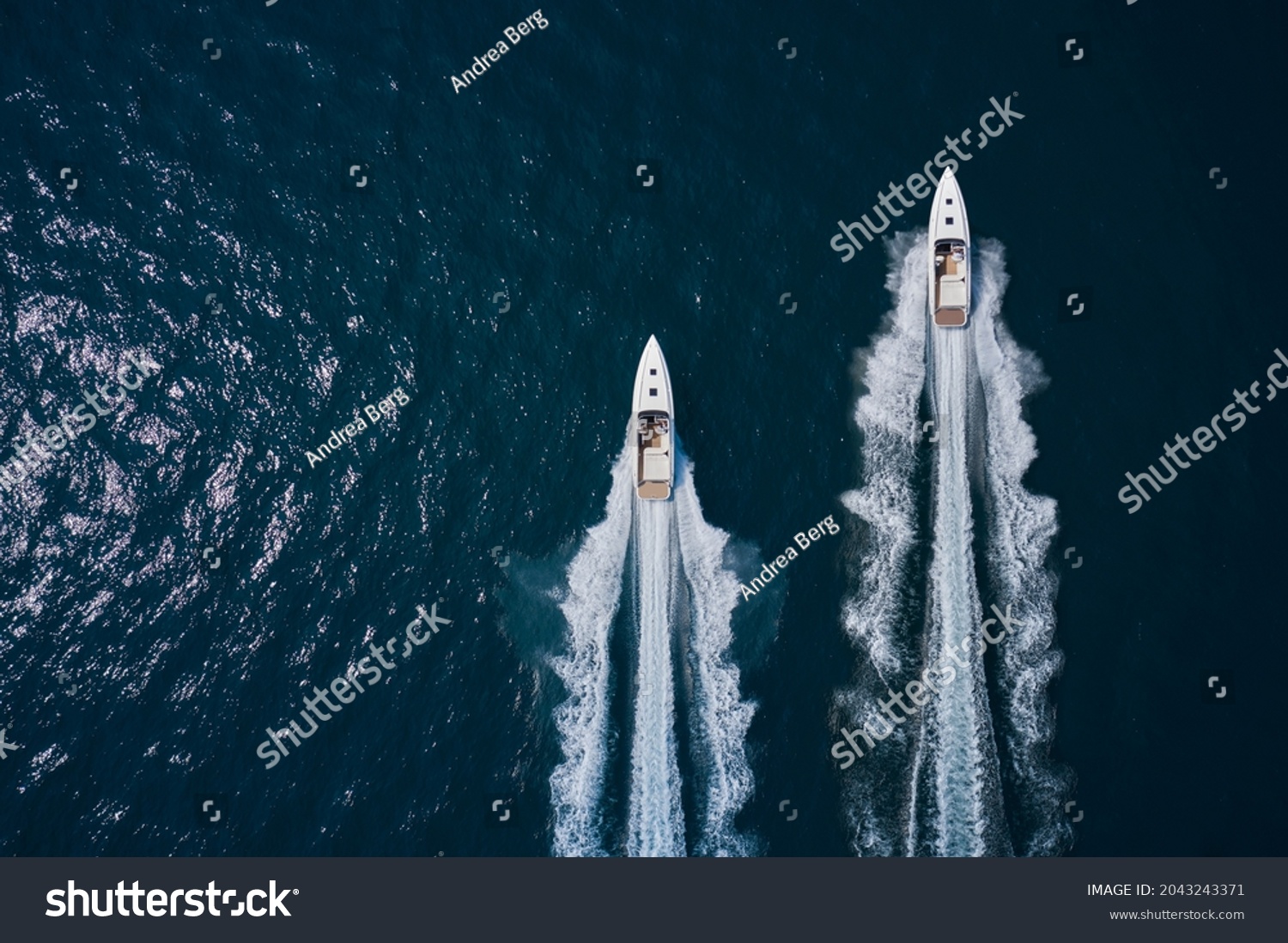 Speed boats movement on the water. Speed boats on dark blue water aerial view. Two speed boats moving fast on dark blue water.. Large white boat driving on dark water. #2043243371
