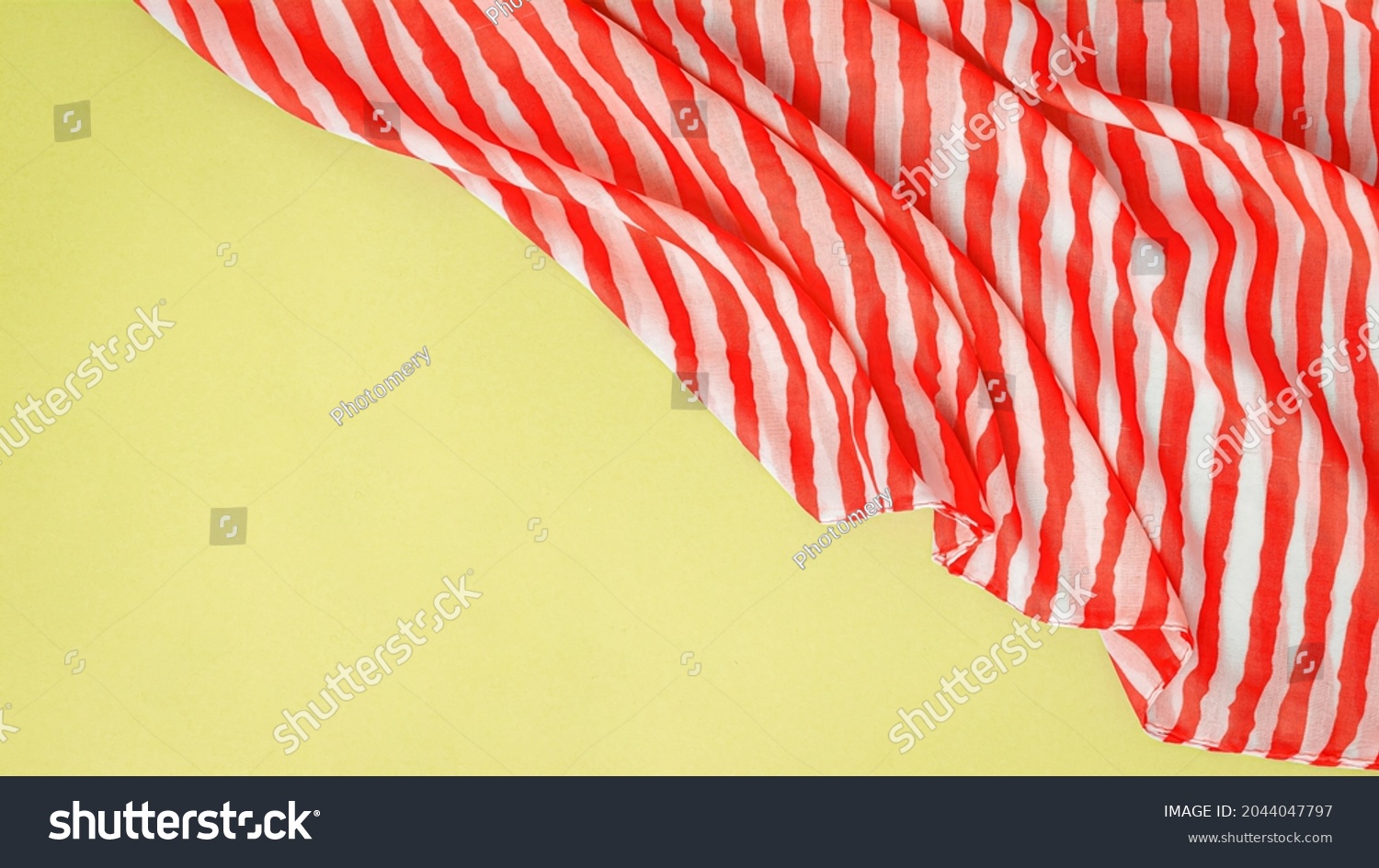 Red striped fabric is wavy thin cloth that having relatively long many band of distinctive color on it. #2044047797