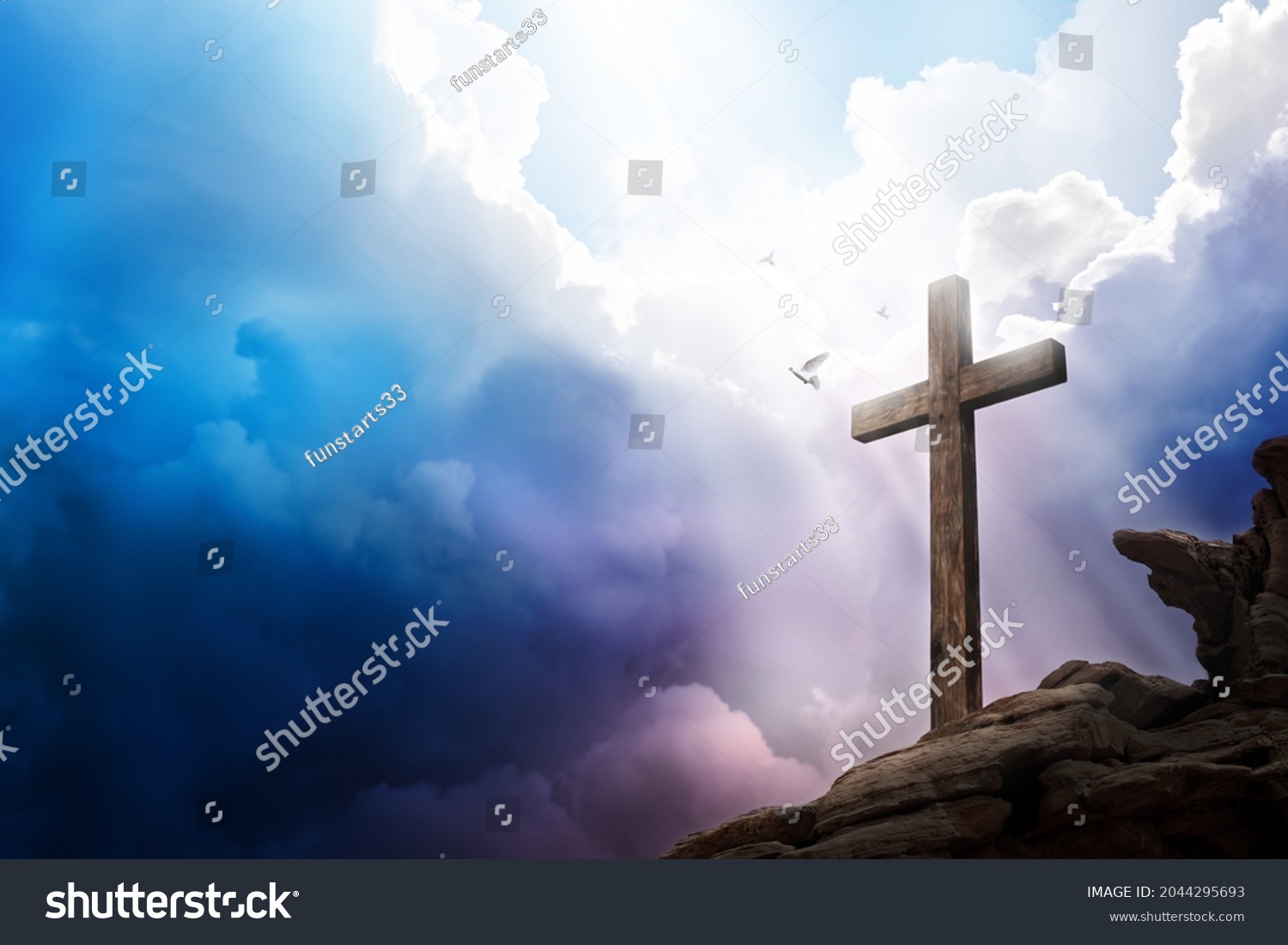 Sky opening up with light rays shining on a cross with doves flying. Religious theme concept. #2044295693