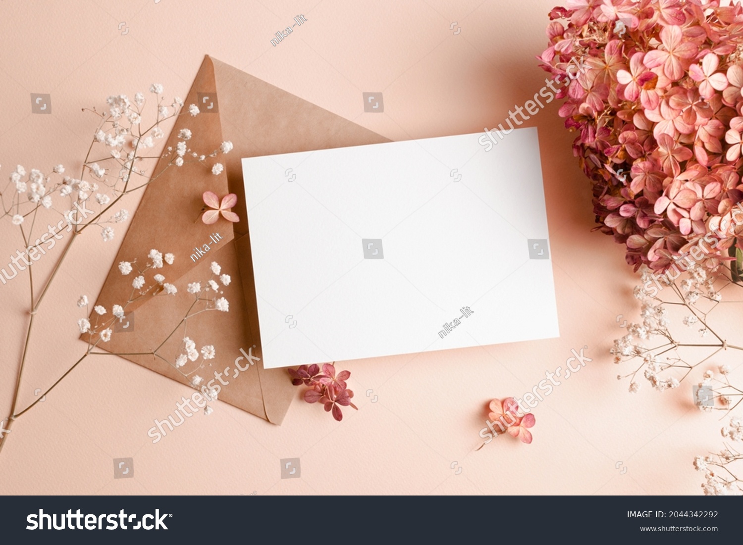 Invitation or greeting card mockup with envelope, hydrangea and gypsophila flowers. Blank card mockup on pink background. #2044342292