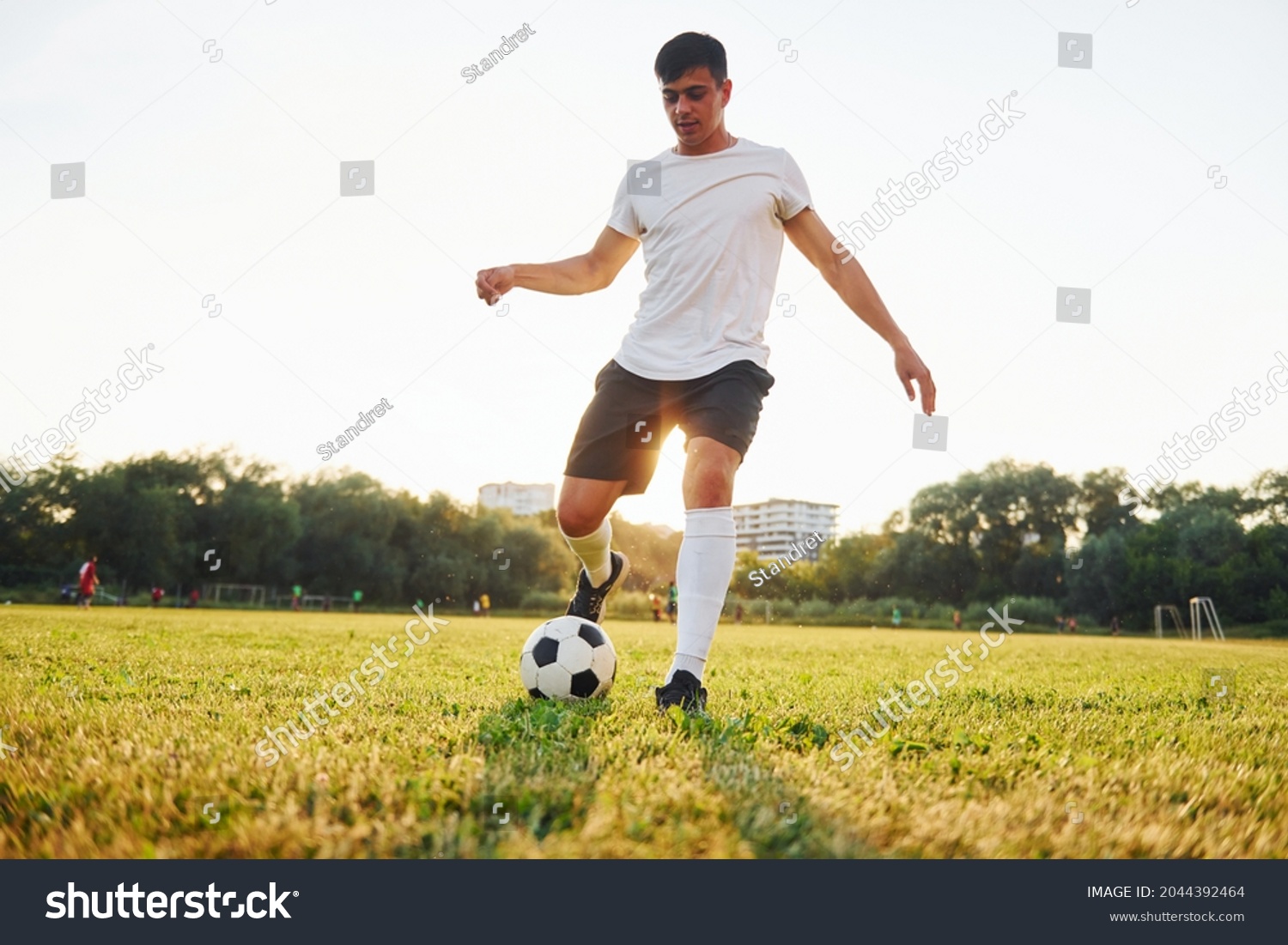 Forest on background. Young soccer player have training on the sportive field. #2044392464