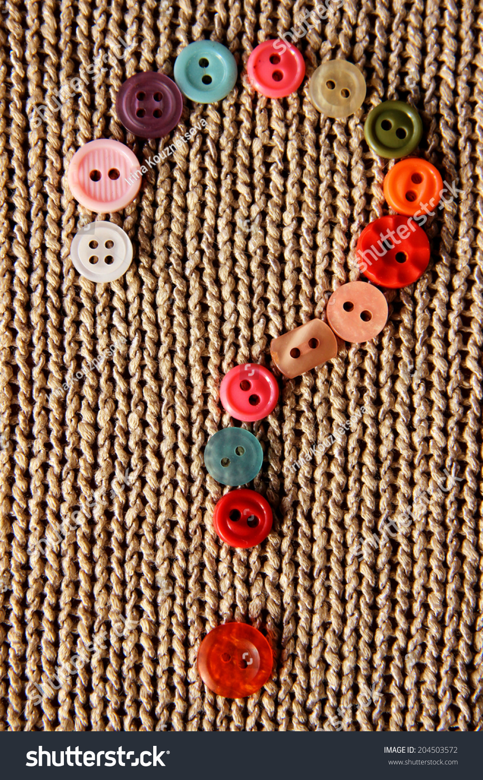 question mark from made in colorful buttons on knitted natural background #204503572