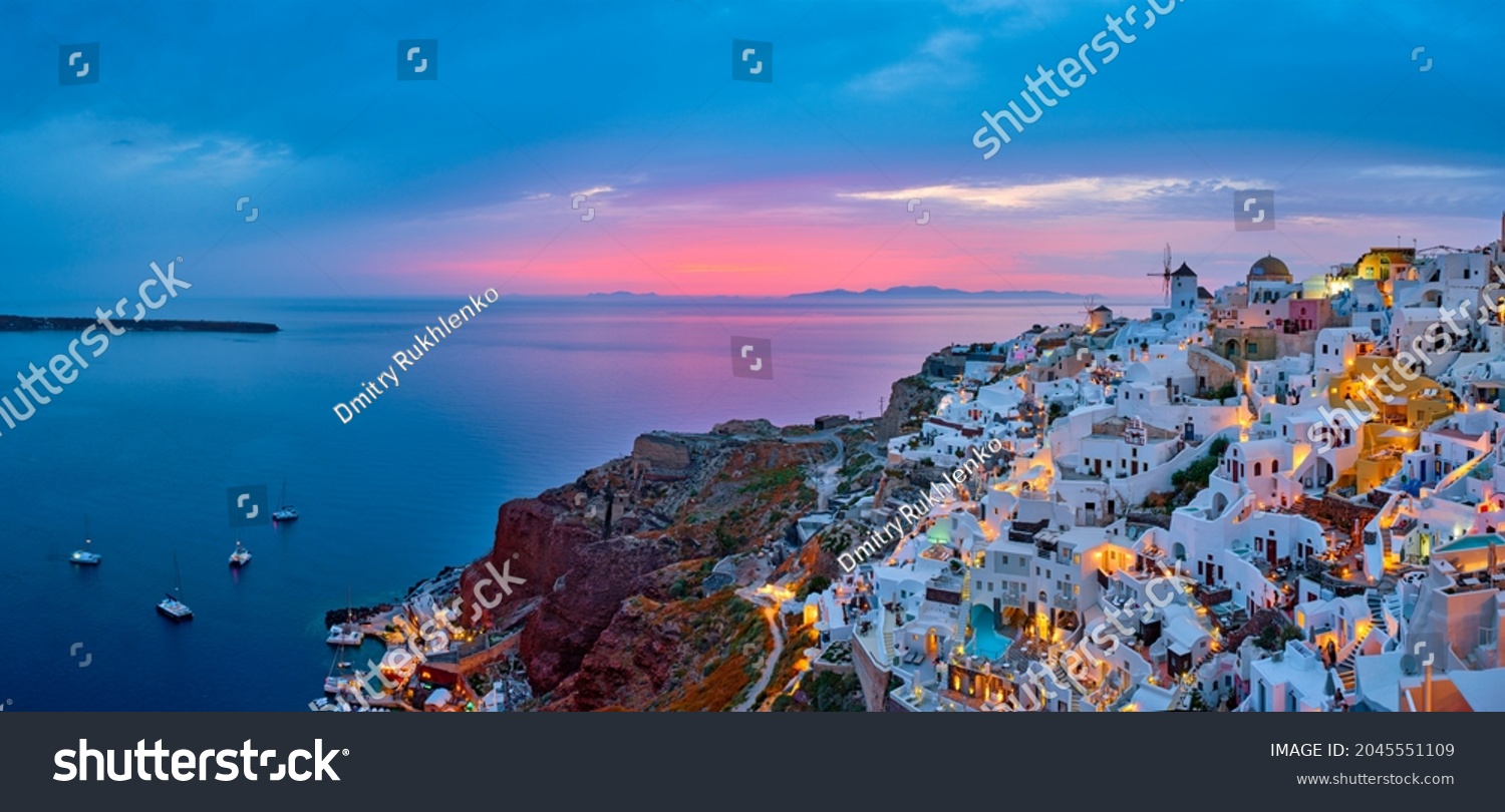 Famous greek iconic selfie spot tourist destination Oia village with traditional white houses and windmills in Santorini island in the evening blue hour, Greece #2045551109