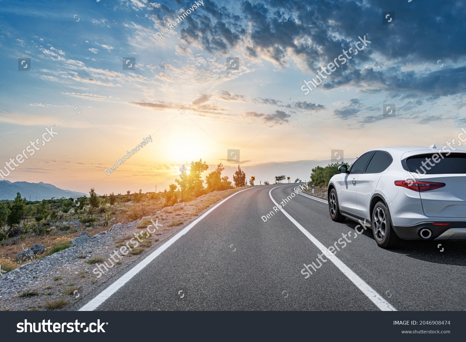White car on a scenic road. Car on the road surrounded by a magnificent natural landscape. #2046908474