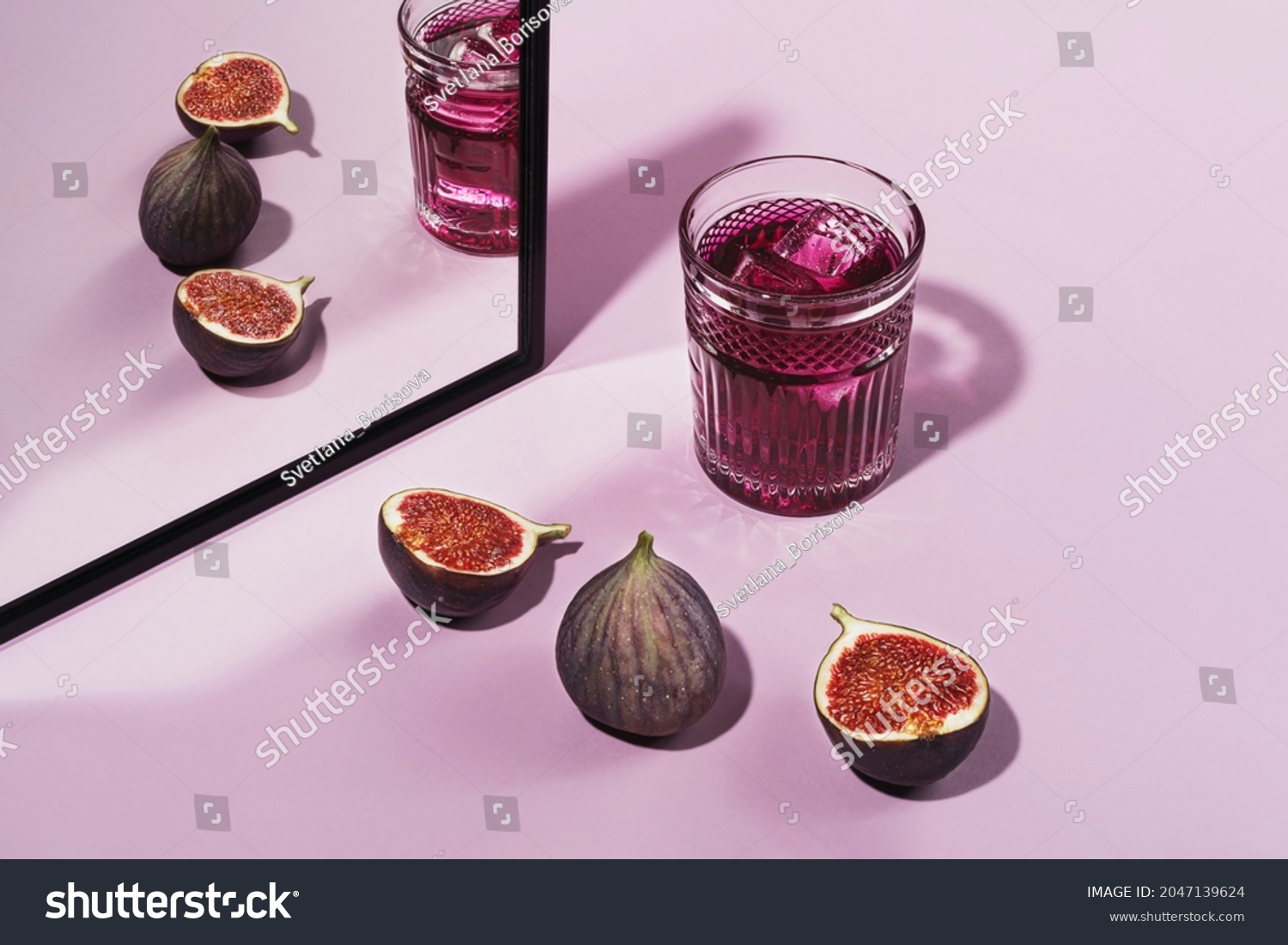 Colorful cocktail garnished with figs. Cocktail purple color garnished with figs, frontal view. On a pink background #2047139624