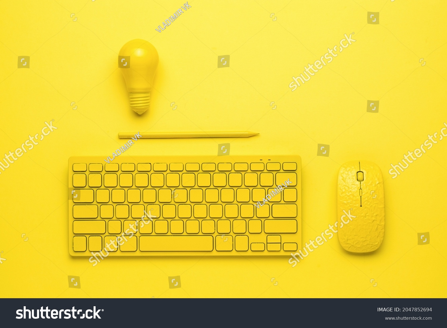 A yellow keyboard with a mouse, a pencil and a light bulb on a yellow background. The concept of business and minimalism. Monochrome. #2047852694