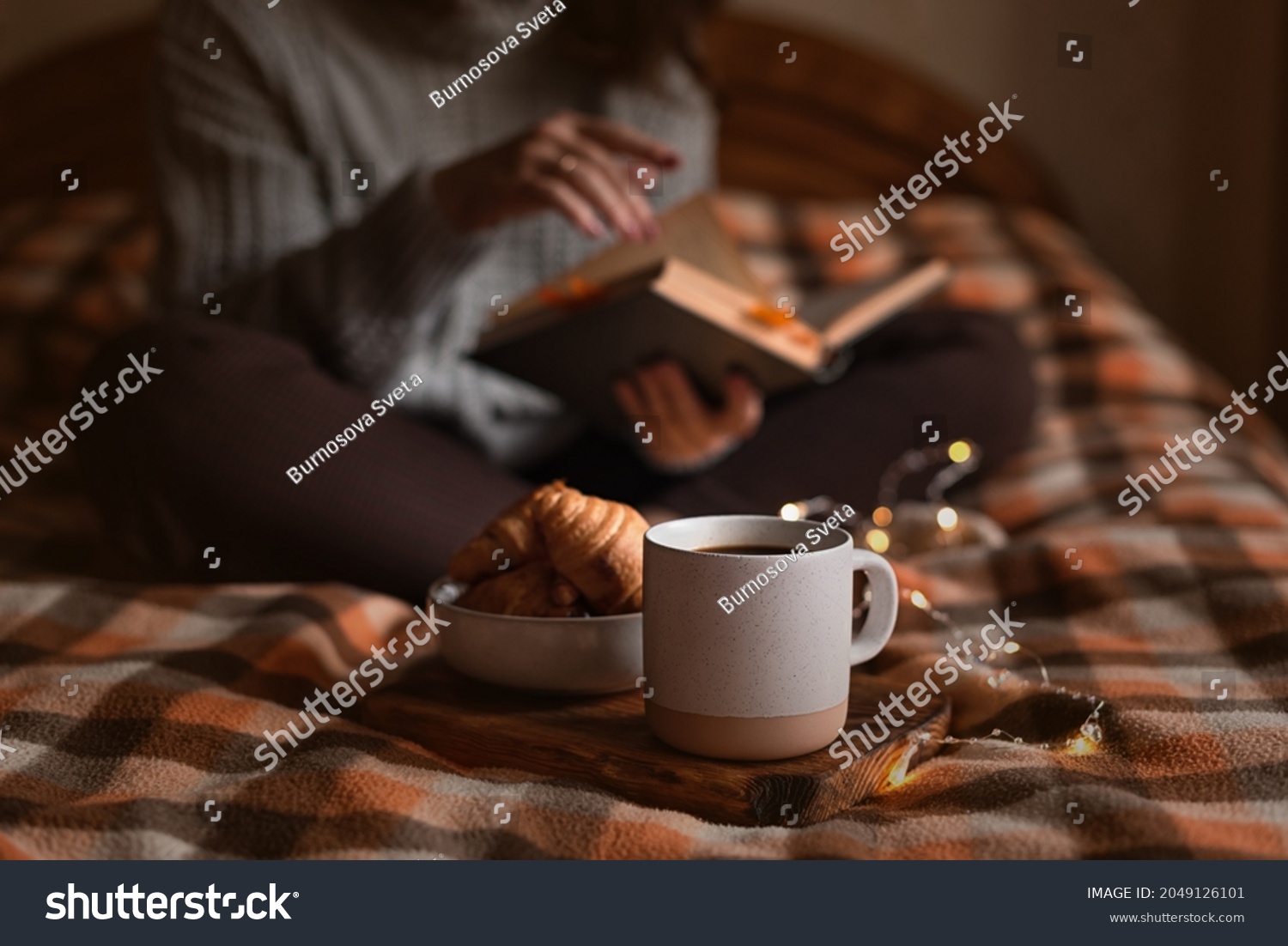 cozy autumn evening: girl, coffee, book and croissants #2049126101