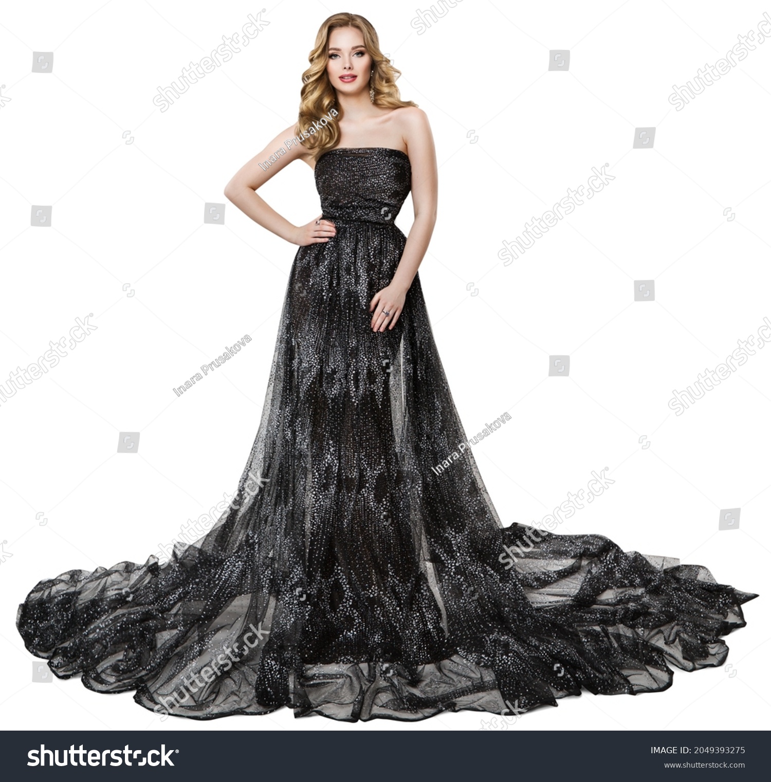 Fashion Model in Long Black Dress. Stylish Woman with Perfect Curly Hairstyle and Make up in Sparkling Holiday Luxury Gown over Isolated White #2049393275