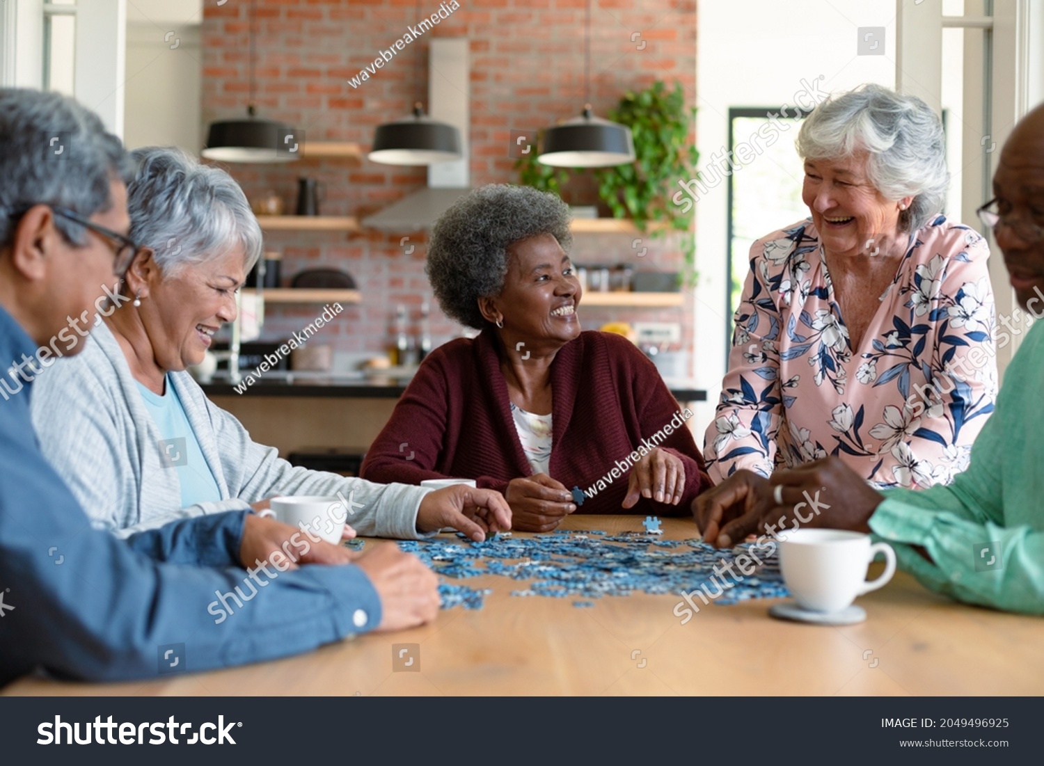 Group of diverse senior male and female friends doing puzzles at home. socialising with friends at home. #2049496925