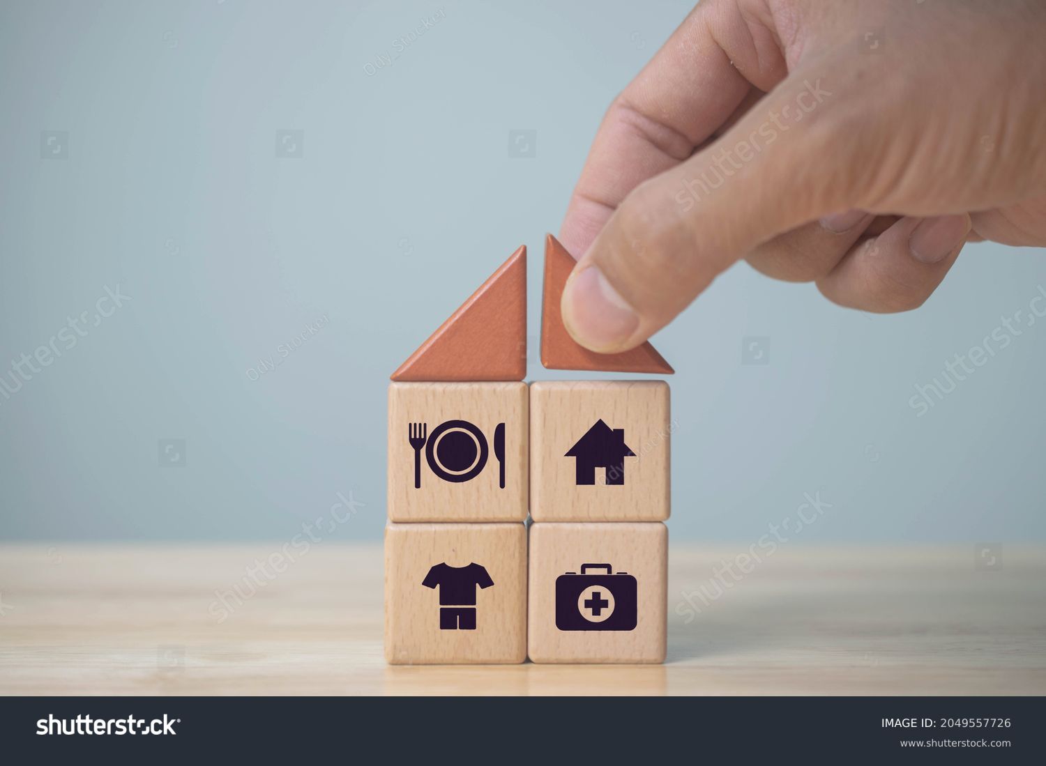 The investor's hand placed a wooden cube with word Work on wooden table. concept work from home, Planning to buy property concept ,food Clothing, housing, medicine, four basic human needs concept. #2049557726
