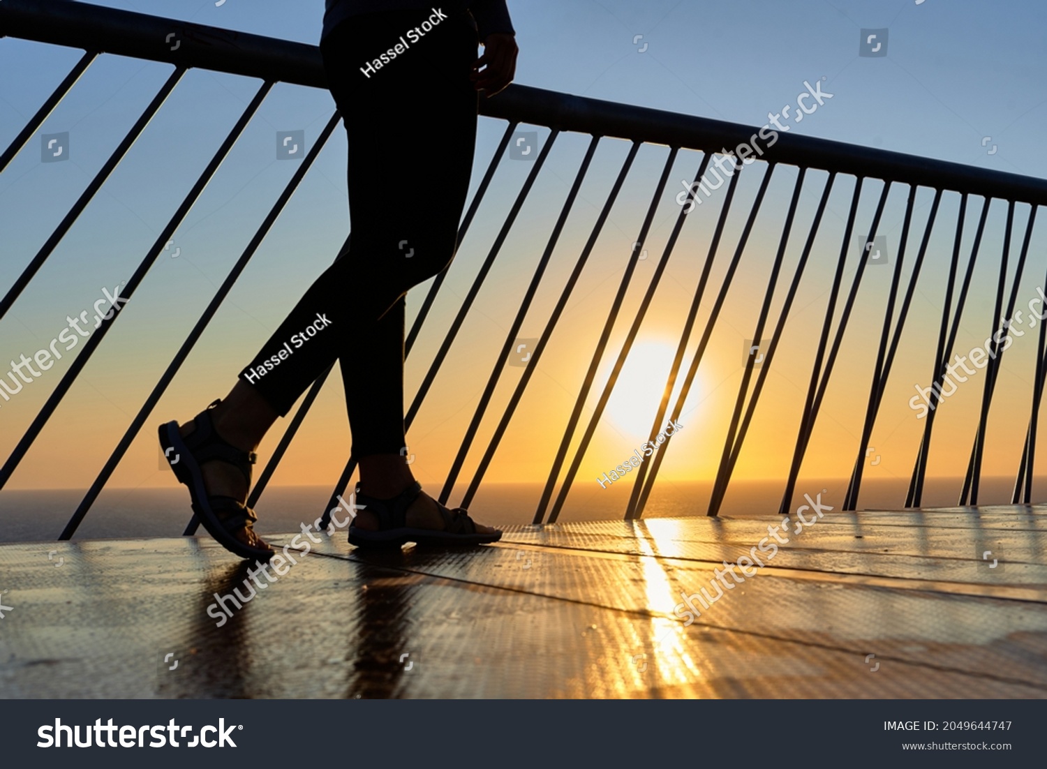 Unrecognizable woman legs walking on a bridge at dawn #2049644747