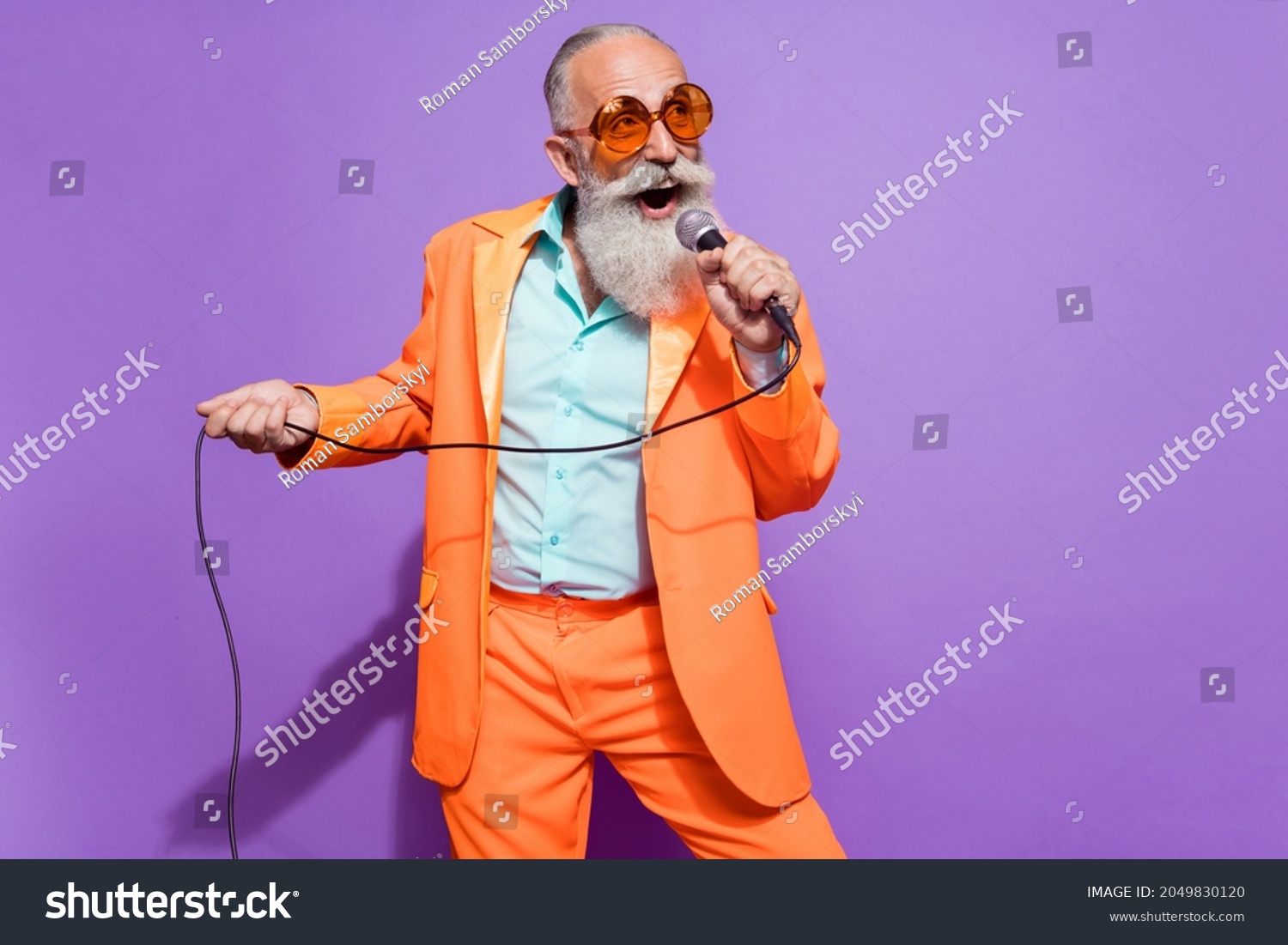 Photo of old dreamy cheerful man sing karaoke stage wear sunglass empty space isolated on purple color background #2049830120