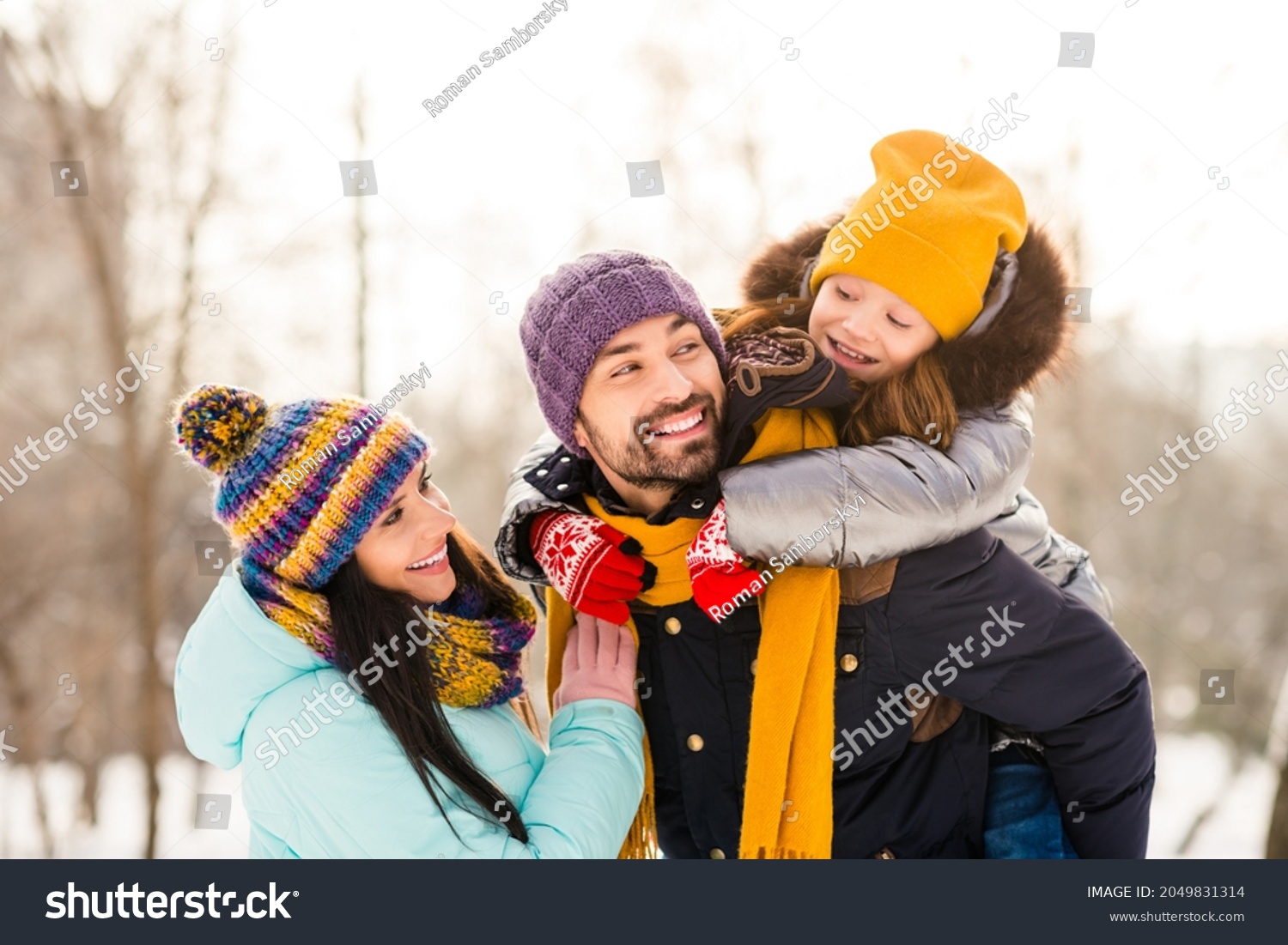 Photo of cheerful family mommy daddy daughter piggyback happy positive smile look each other winter trip outdoors #2049831314