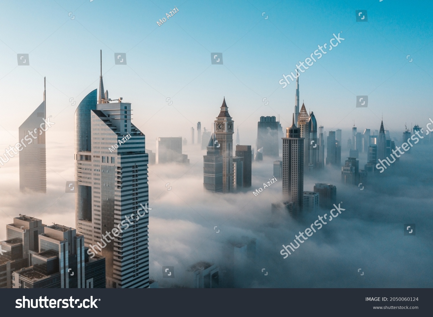 Mega tall skyscrapers of Dubai covered in early morning think fog. Rare aerial perspective.  #2050060124