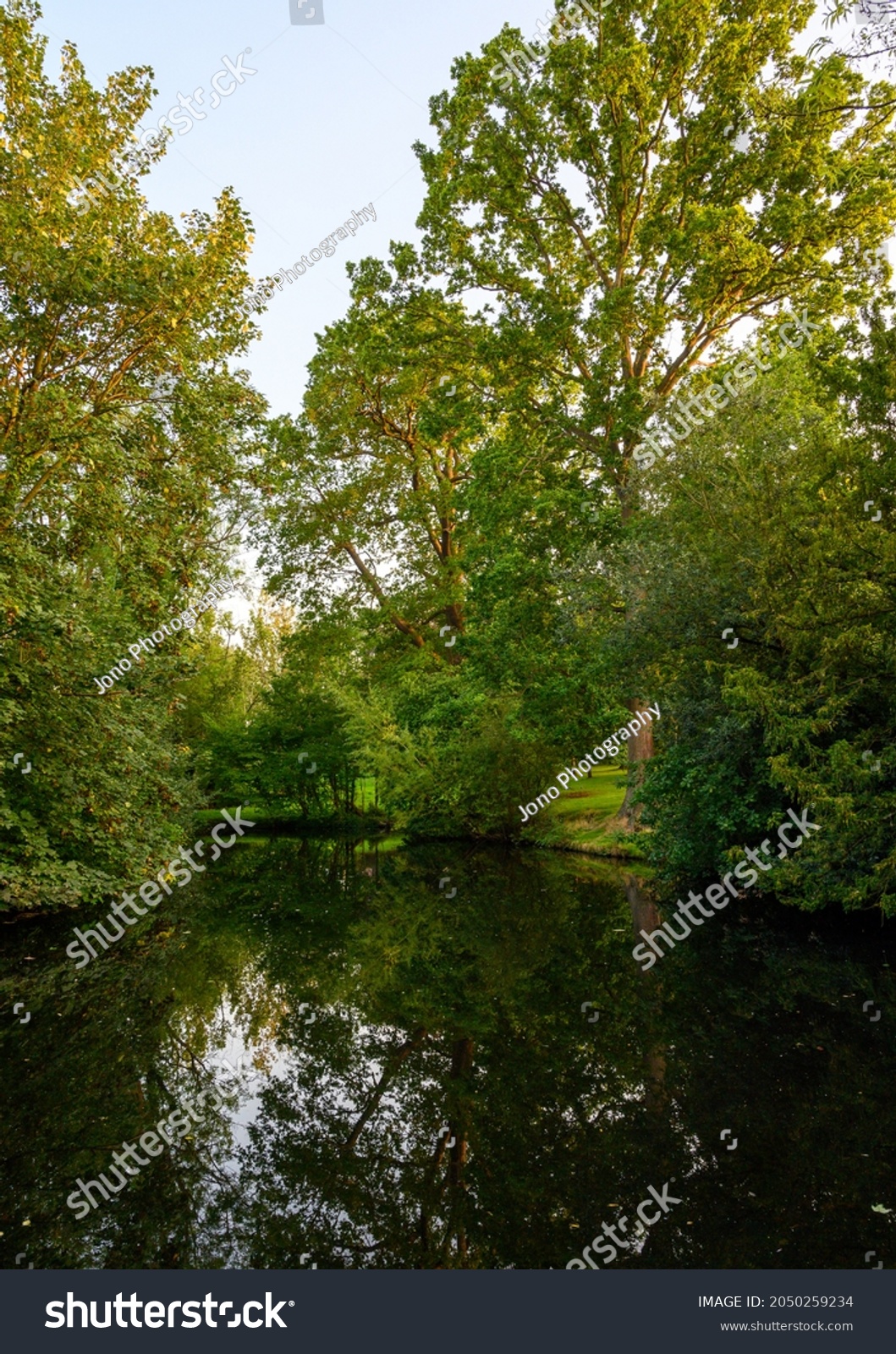 Reflections on the water of a small lake or pond with trees. This lake is in The Knoll, a small PUBLIC PARK in Hayes, Kent, UK. Hayes is in the Borough of Bromley in Greater London. #2050259234