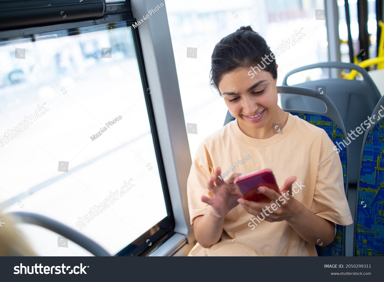 Indian Woman ride in public transport bus or tram with mobile phone #2050299311