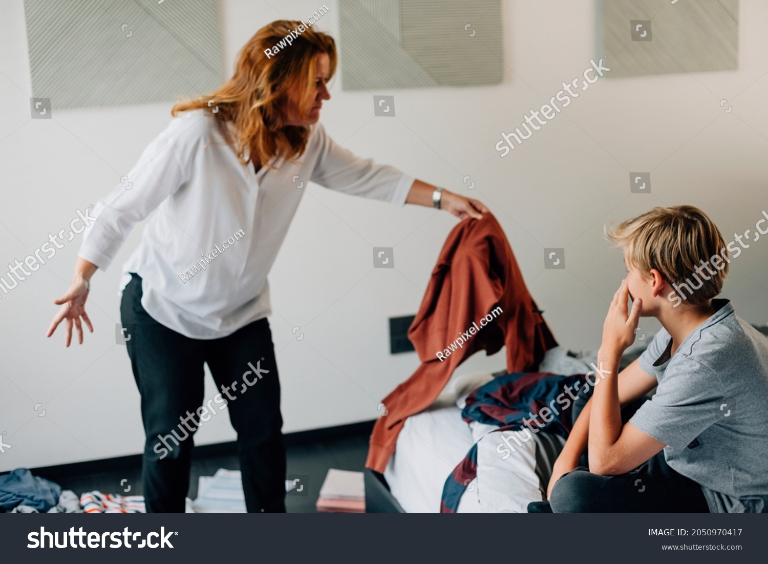 Mother scolding son for messy bedroom #2050970417