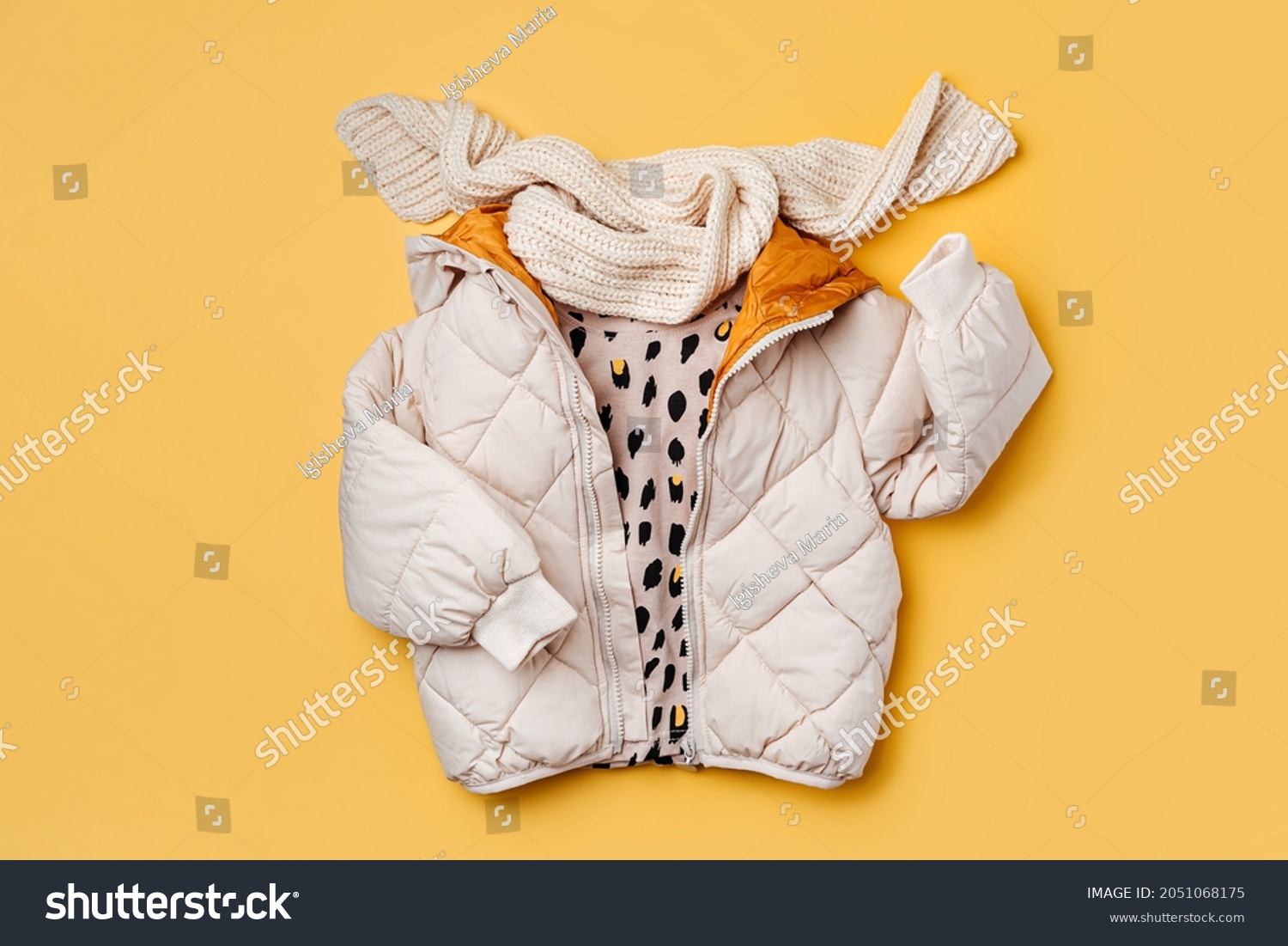 Kids warm puffer jacket with scarf on yellow  background. Stylish childrens outerwear. Winter fashion outfit  #2051068175