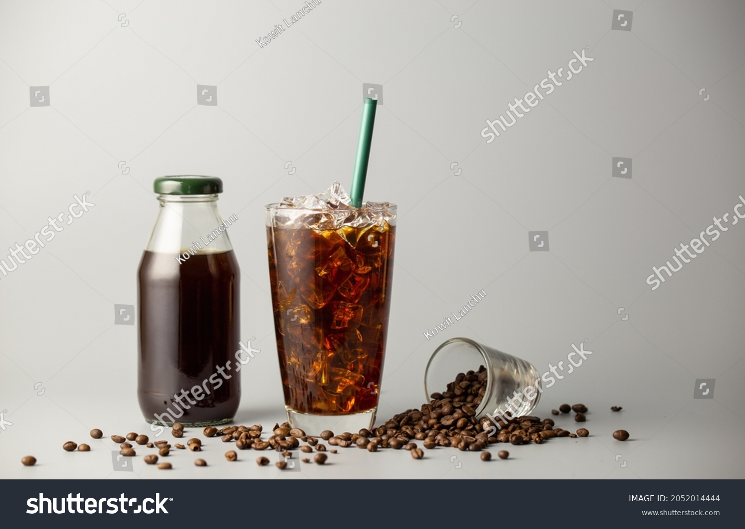 Iced americano coffee with coffee beans on grey background, Black coffee glass package for takeaway. Cold beverage product. #2052014444