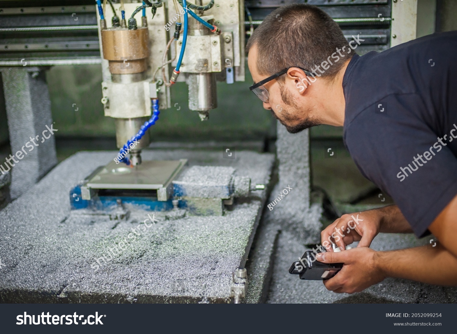 Engineer worker technician operating with CNC milling metal engraving machine in factory workshop. #2052099254