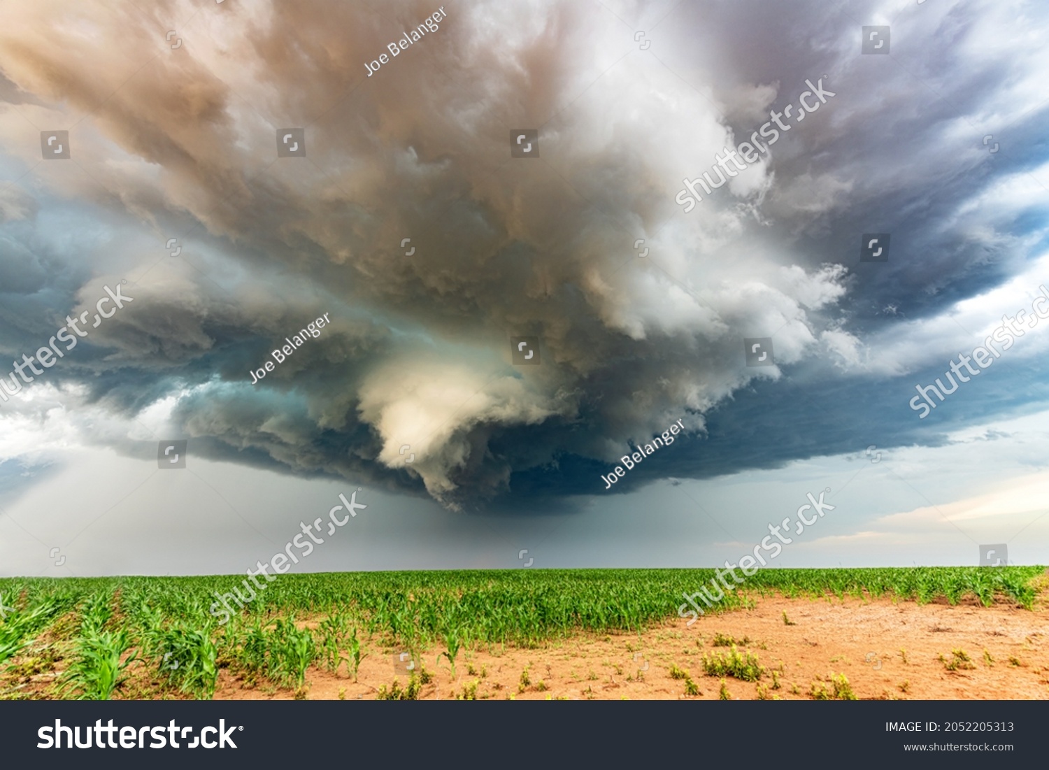 Panorama of a massive mesocyclone weather supercell, which is a pre-tornado stage, passes over a grassy part of the Great Plains while fiercely trying to form a tornado. #2052205313