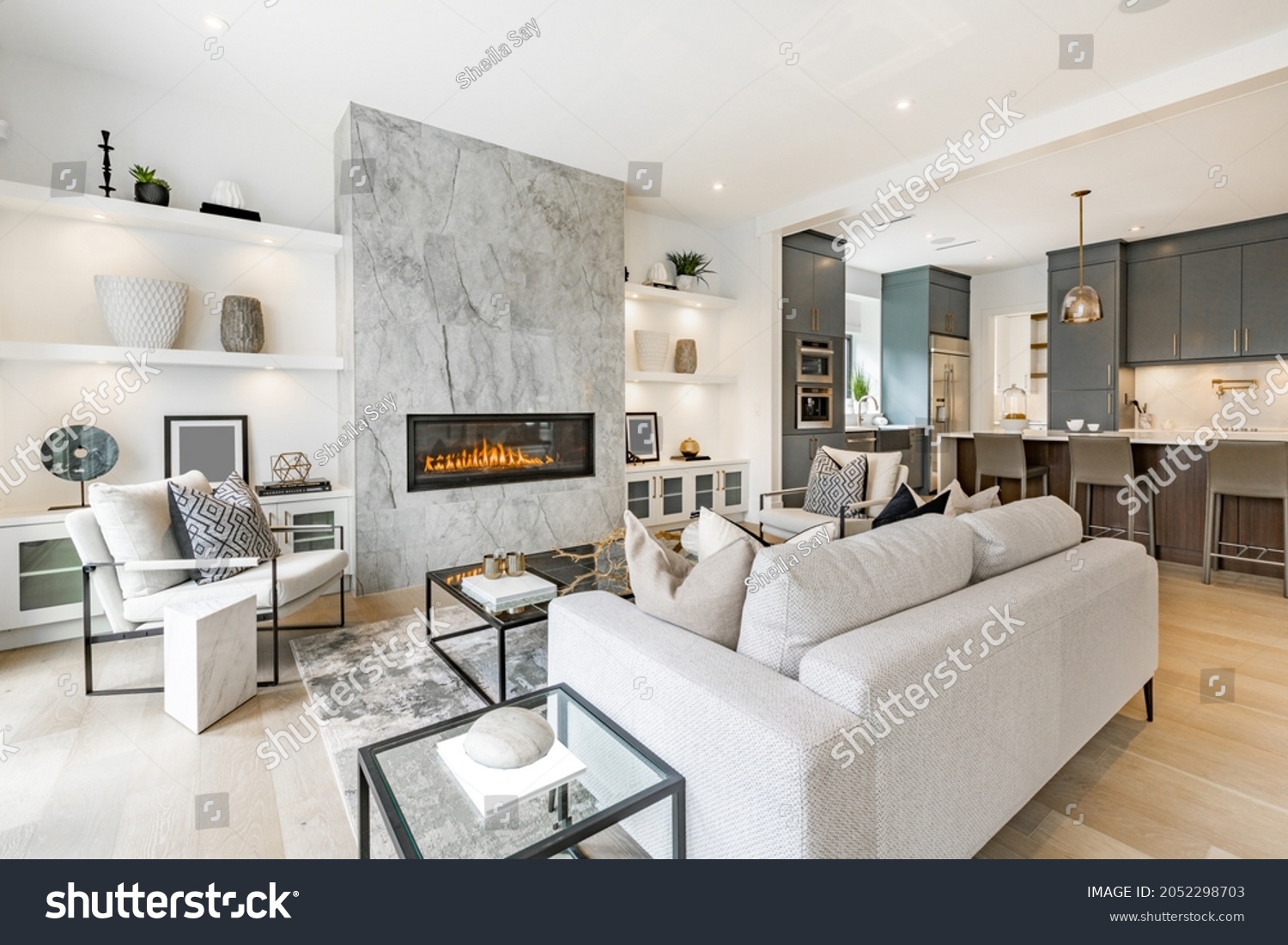 contemporary living room with open concept view through to dining room kitchen and a marble fireplace with gas fire #2052298703