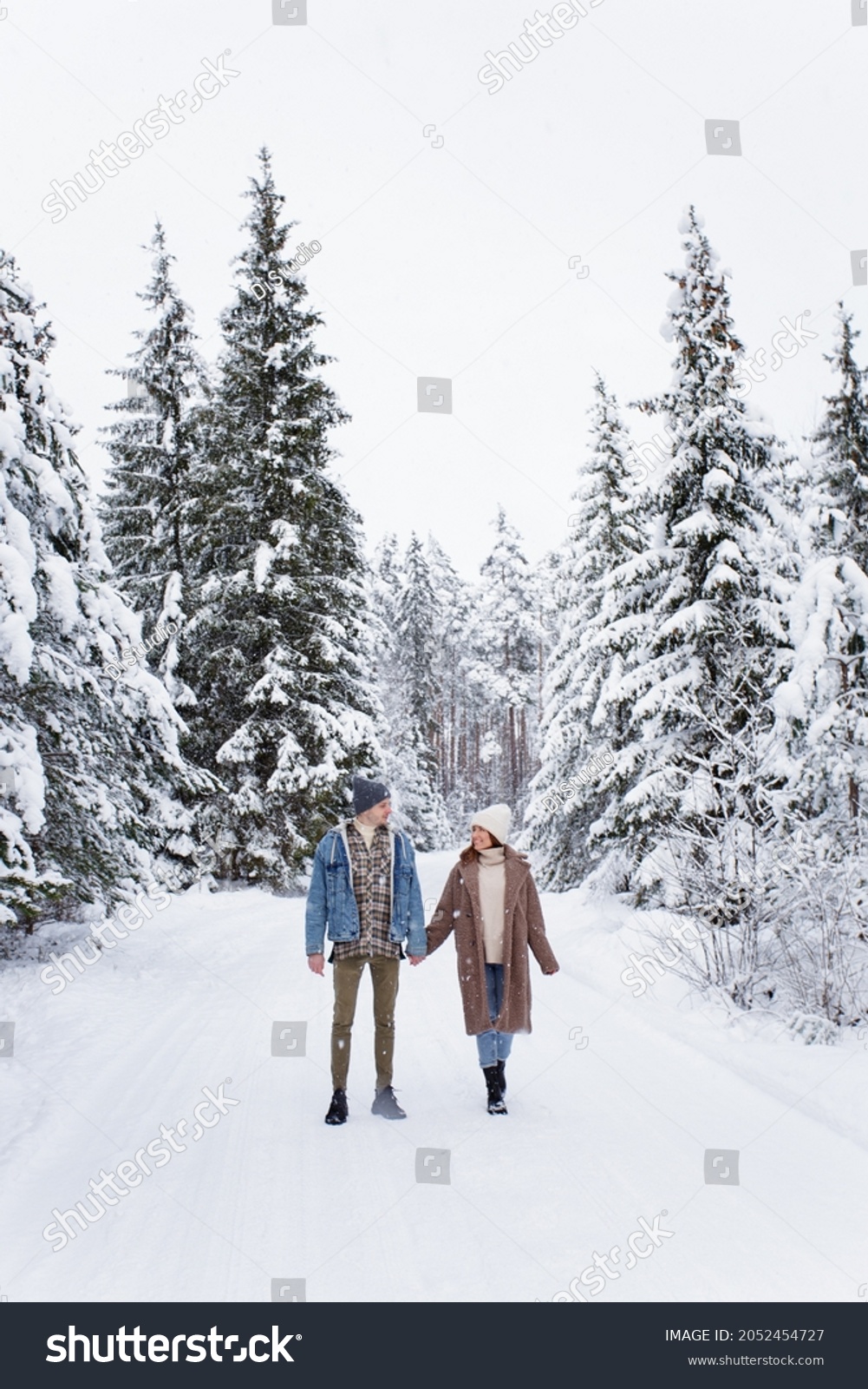 full length portrait of happy young couple walking in winter forest #2052454727