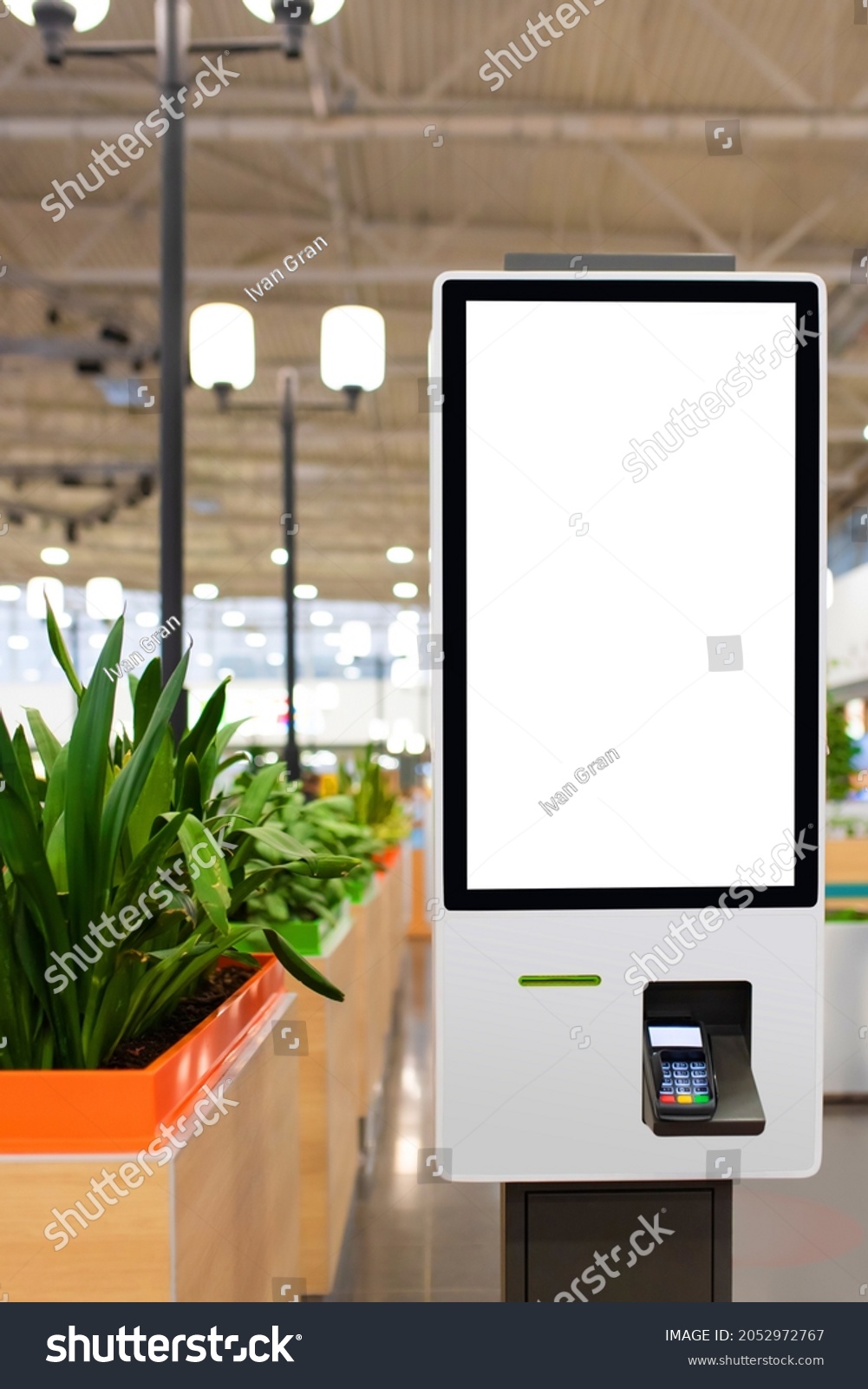 Self service electronic counter with blank mockups on white screen and payment terminal in fast food restaurant, shopping mall #2052972767