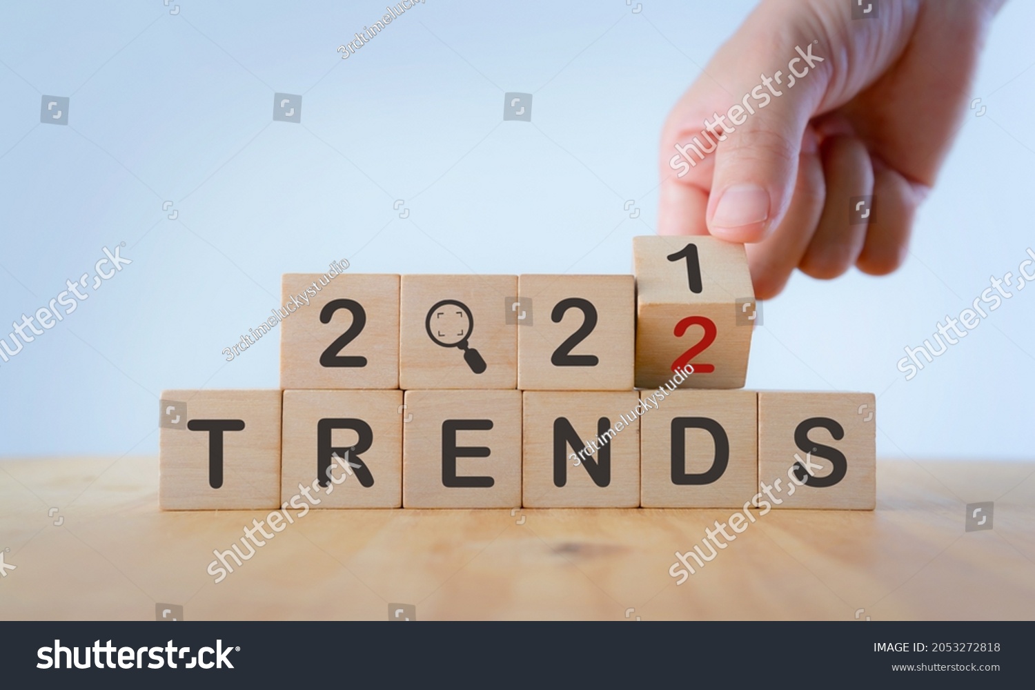 2022 trend concept. Hand flip wooden cube change year 2021 to 2022. Beautiful white background, copy space. Used for banner in trend concept in new year for monitoring new business opportunities. #2053272818