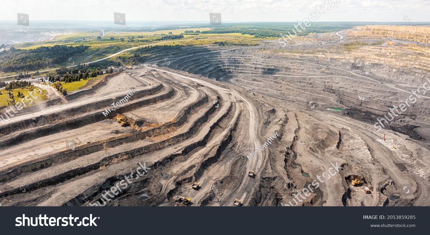 Panoramic aerial view of coal mine. Open pit mine industry, big yellow mining truck for coal quarry. Open coal mining anthracite mining. Pit on coal mining by open way. Rock loading in trucks #2053859285