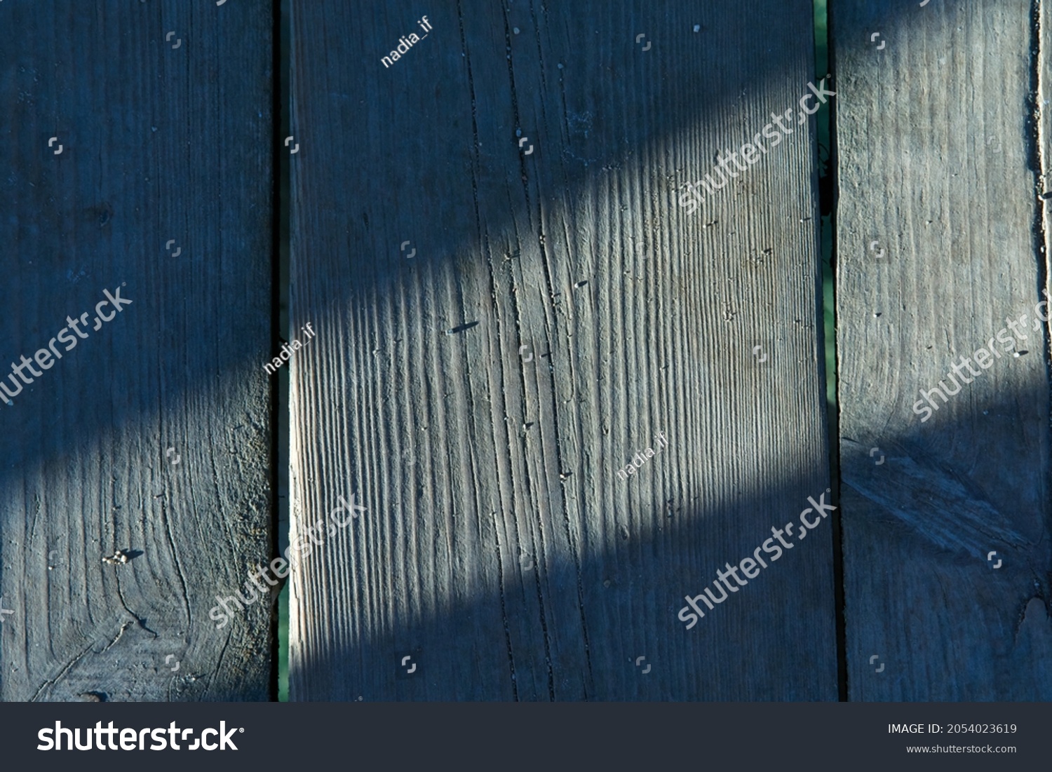 Gray wooden background with vertical lines and autumn ray of sunshine. Board background with copy space. Texture wooden background. High quality photo #2054023619