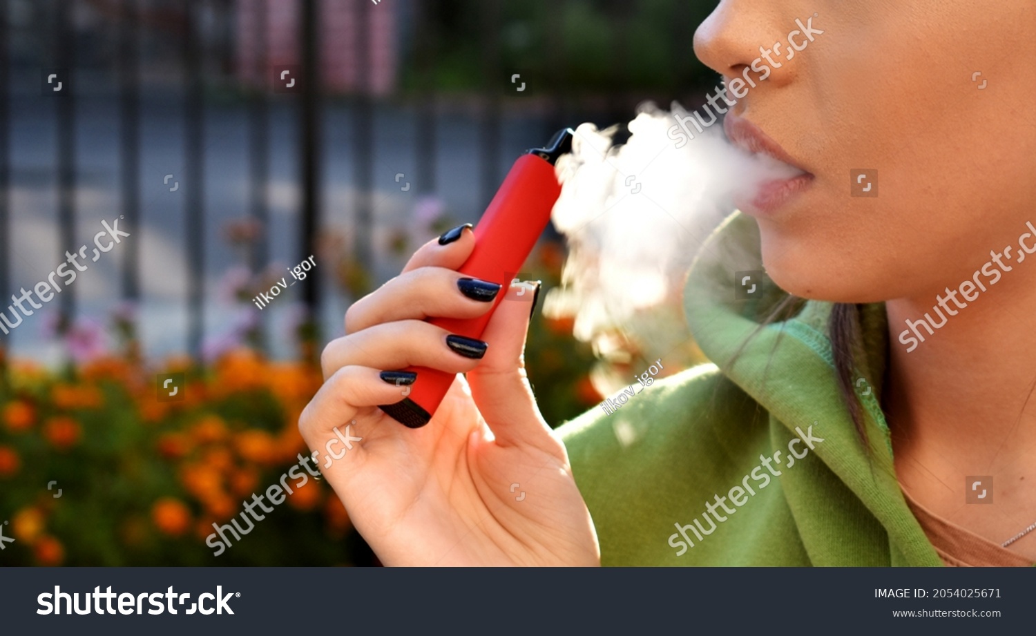 beautiful women smoke electronic cigarette in street #2054025671