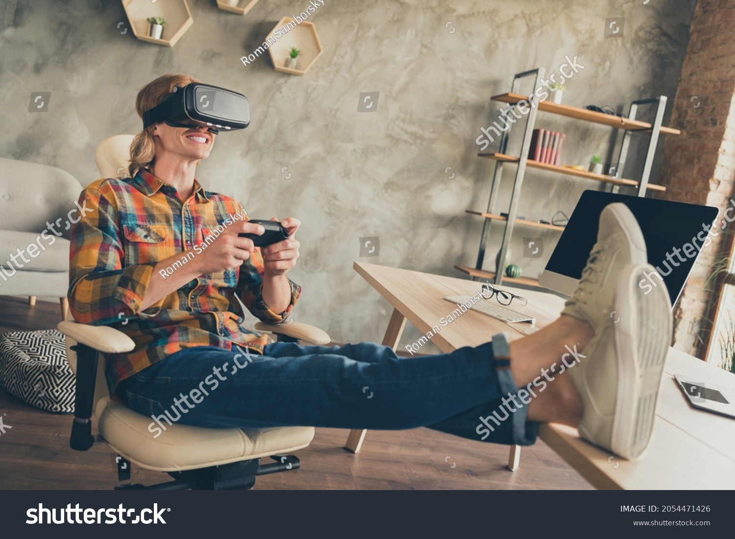 Photo portrait man in vr glasses checkered shirt playing video games with joystick after hard day #2054471426