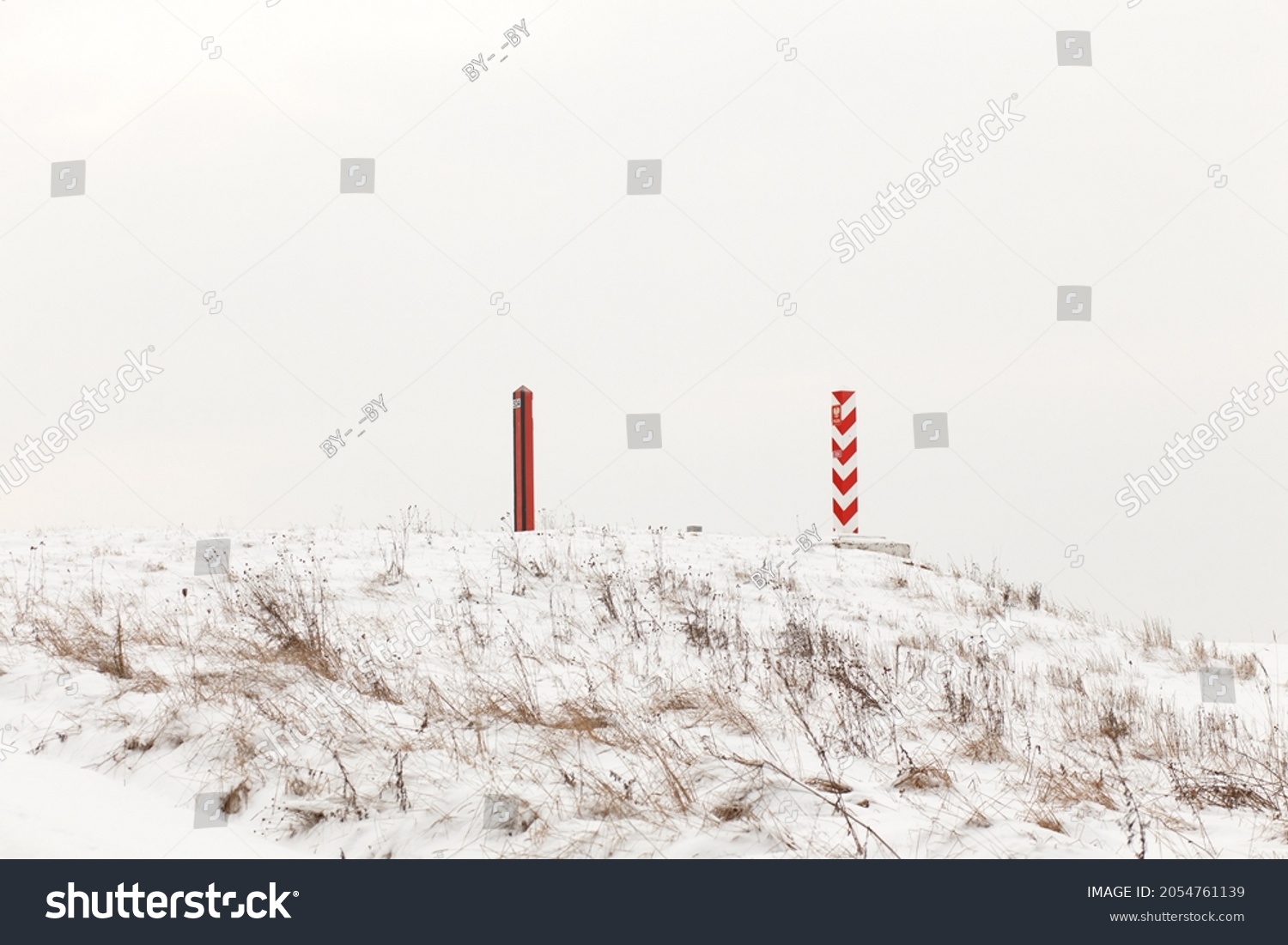Boundary pillars of Belarus and Poland on the border in a winter field #2054761139