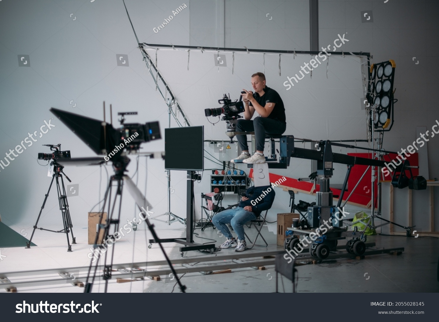 Film set, monitors and modern shooting equipment. Film crew, lighting devices, monitors, playbacks - filming equipment and a team of specialists in filming movies, advertising and TV series #2055028145