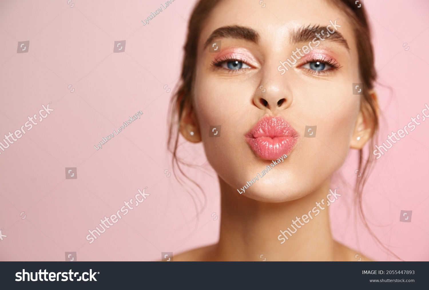 Cosmetics and skin care. Portrait of beautiful woman pucker lips, kissing, showing natural clean facial skin, standing over pink background #2055447893