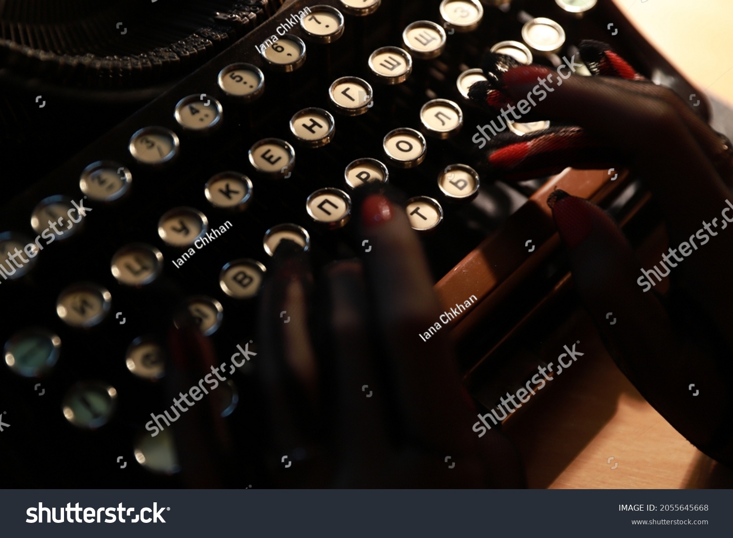Typewriter mechanism, hands on a printed bag, light from a lamp, sheet of paper, typewriter, keys #2055645668