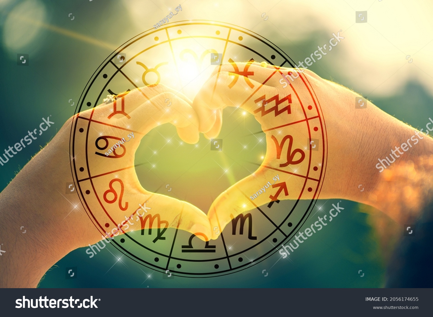 The hands of women and men are the heart shape with the sun light passing through the hands have astrological symbols #2056174655