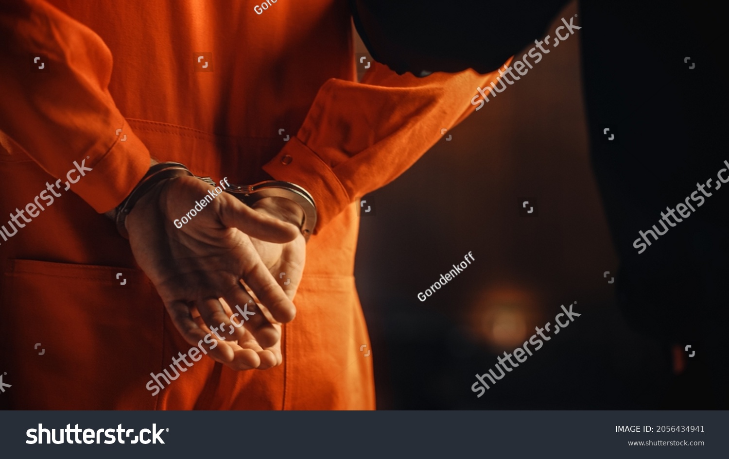 Arrested Handcuffed Convict at a Law and Justice Court Trial. Handcuffs on Accused Criminal in Orange Jail Jumpsuit. Law Offender Sentenced to Serve Jail Time. #2056434941