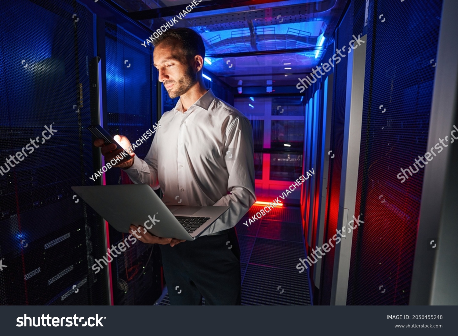 IT specialist using security appliance and laptop for server administration #2056455248