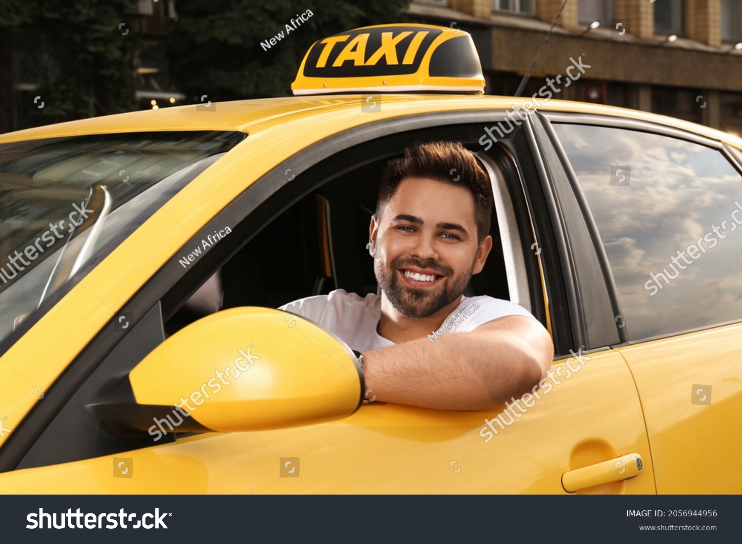 Handsome taxi driver in car on city street #2056944956