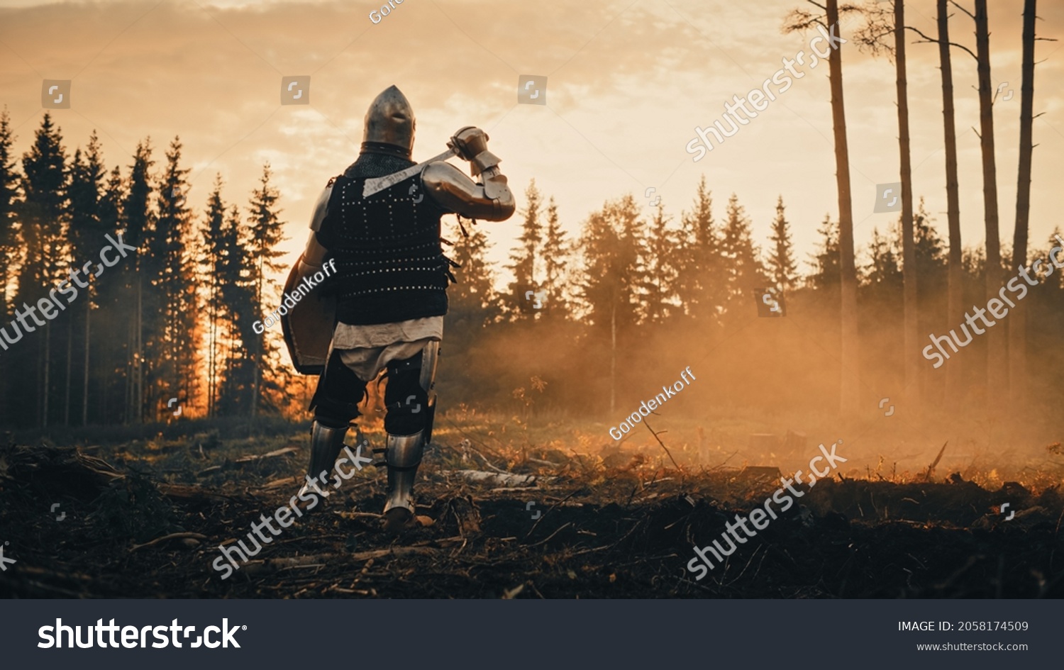 Medieval Knight Looking at Sunrise. Romantic Hero, Soldier, Warrior in Body Armour with Sword On a Journey to Safe Princess. Mysterious Smoke, Magic Forest and Adventure. Back View Shot #2058174509