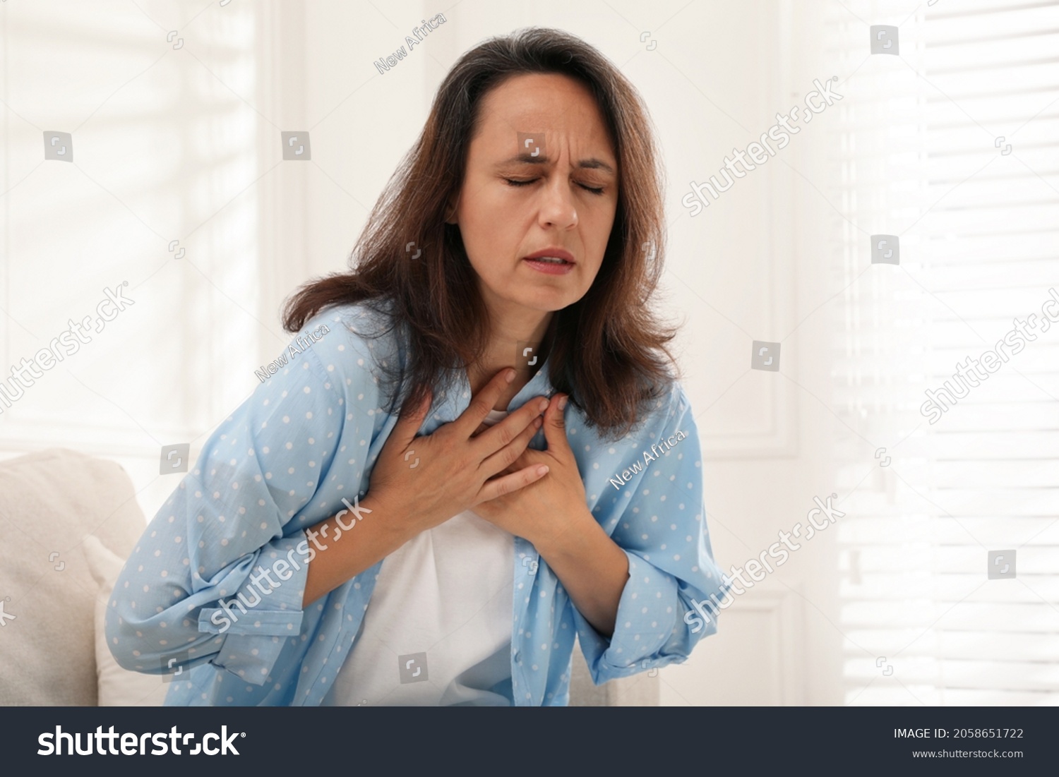 Mature woman suffering from breathing problem at home #2058651722