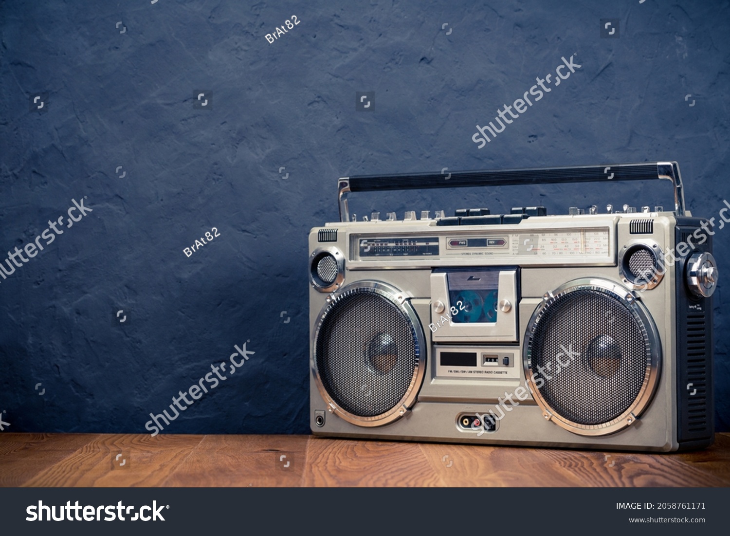 Retro boombox ghetto blaster outdated portable radio receiver with cassette recorder from 80s front concrete black wall background. Rap, Hip Hop music concept. Vintage old style filtered photo #2058761171