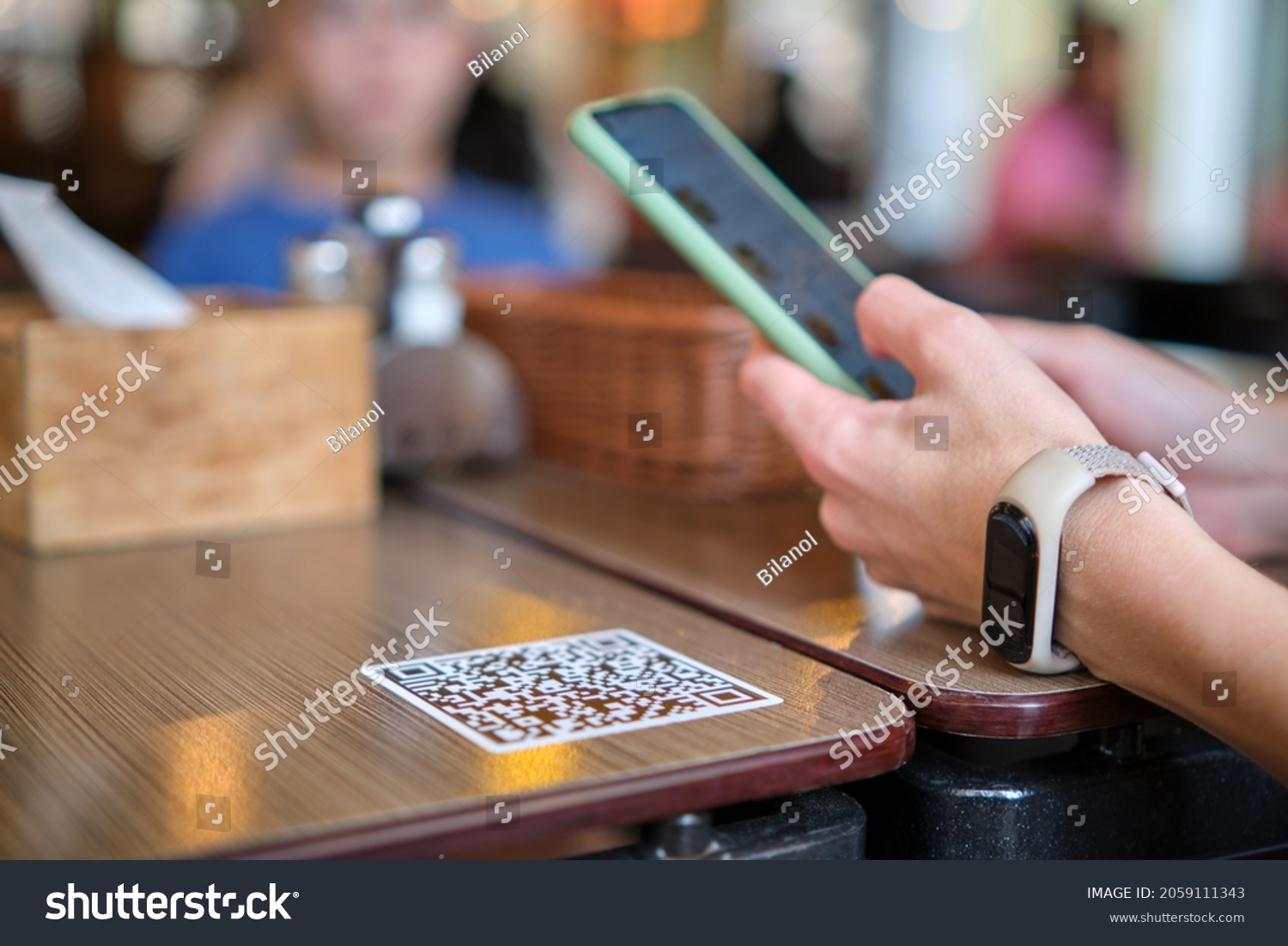 Closeup of guest hand ordering meal in restaurant while scanning qr code with mobile phone for online menu. #2059111343