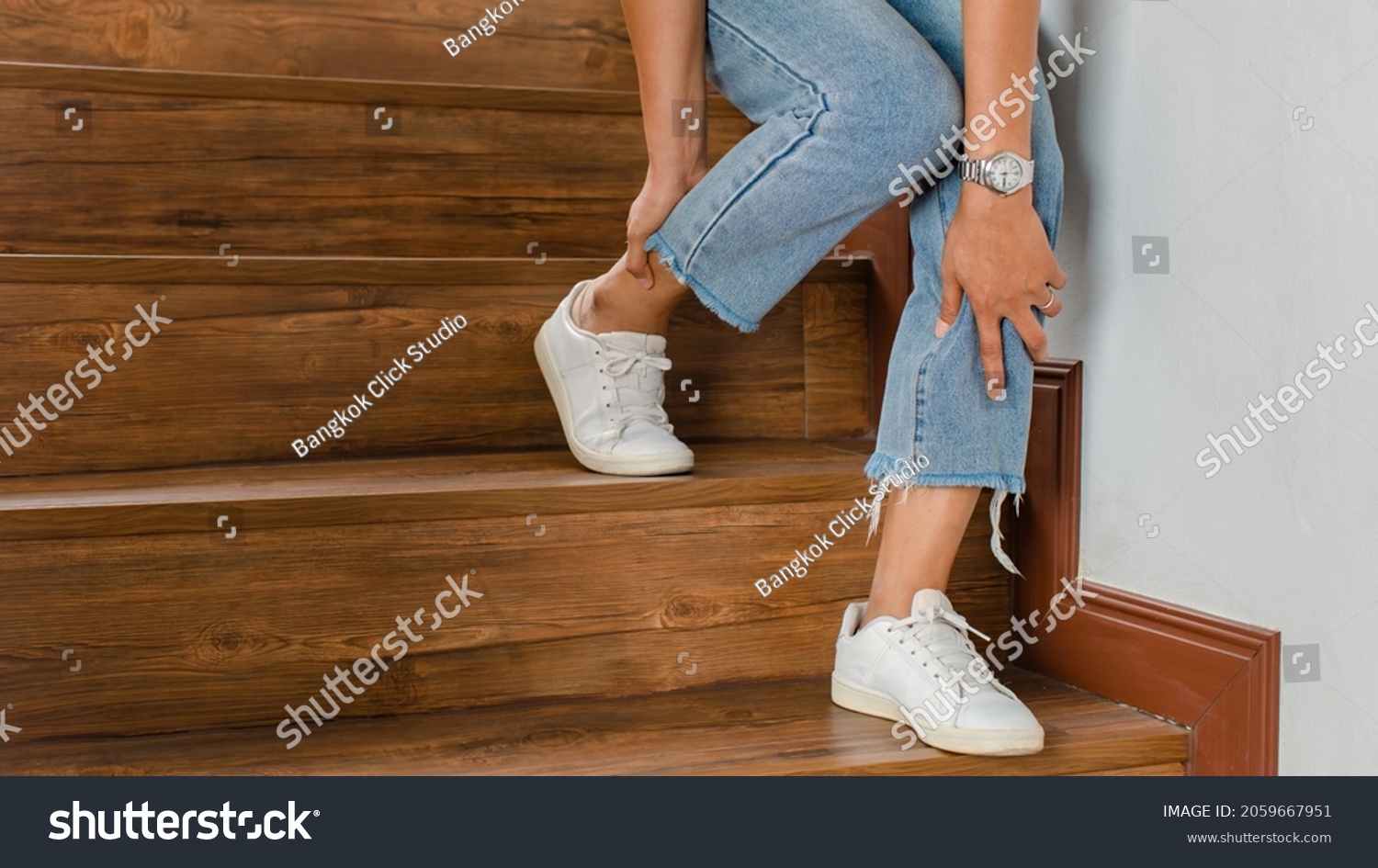 Woman loses control and cannot walk on stairs, she stops and hold her legs for support and rest with feel tingling. Concept of Guillain barre syndrome and numb legs disease or vaccine side effect. #2059667951