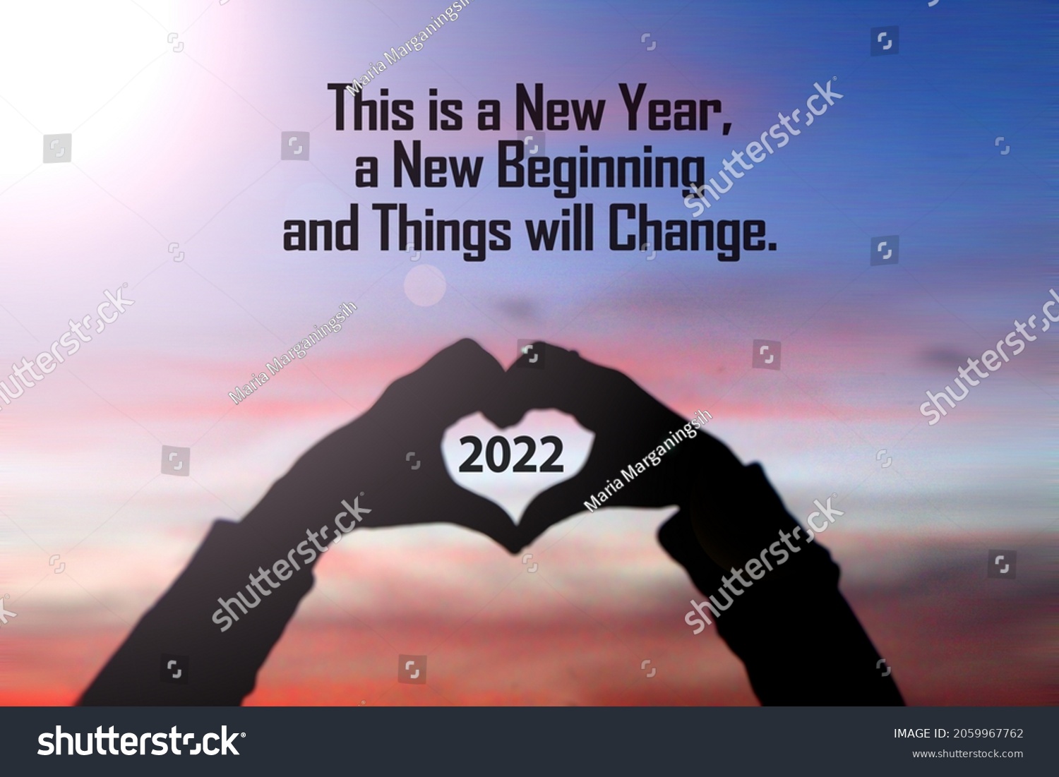 New year inspirational motivational quote - This is a new year a beginning, things will change. Silhouette of a person holding a heart shaped hands with 2022 number inside. On sunset sky background. #2059967762