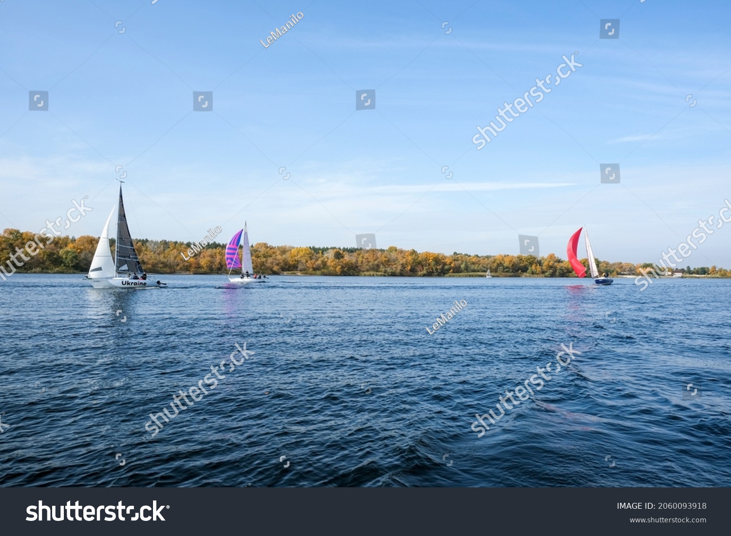 Sailing yachts with colored sails in pursuit race, side view #2060093918