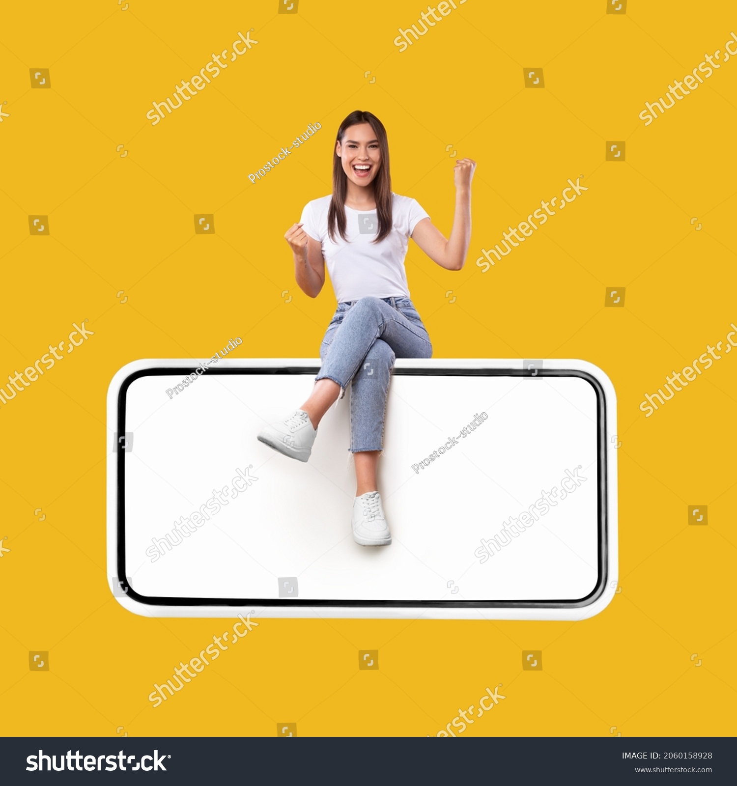Yes. Excited Woman Sitting On Big Smartphone With Empty White Screen Shaking Clenched Fists, Cheerful Lady Celebrating Win Isolated On Yellow Orange Background, Mock Up Collage, Full Body Length #2060158928